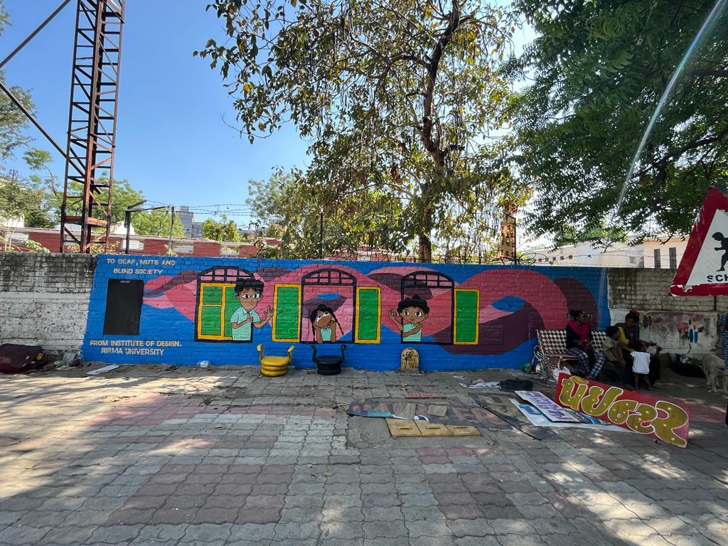 Modern home office setup with a monitor, ergonomic chair, keyboard, and indoor plants near a window with blinds.