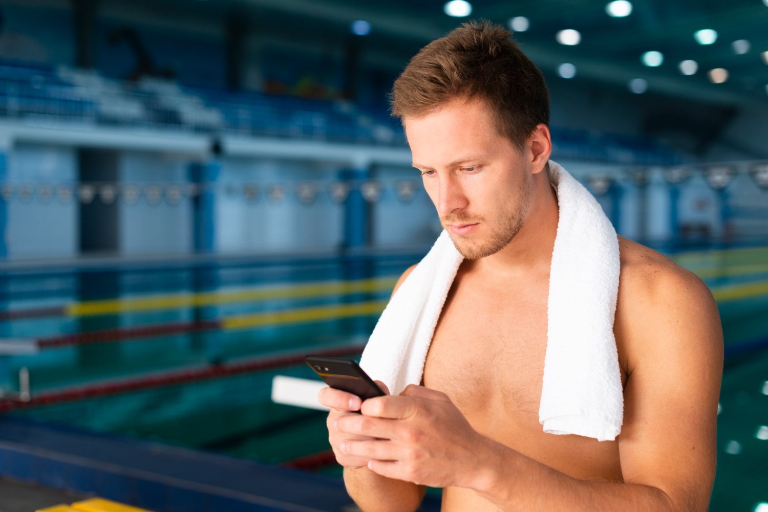 triathlonista sprawdzający plan treningowy na basenie