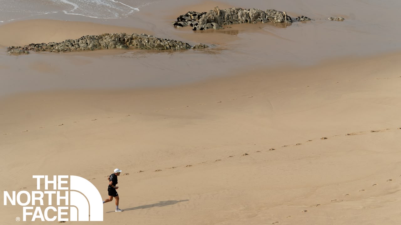 a person running along the beach section of the Robberg Express Trail Run