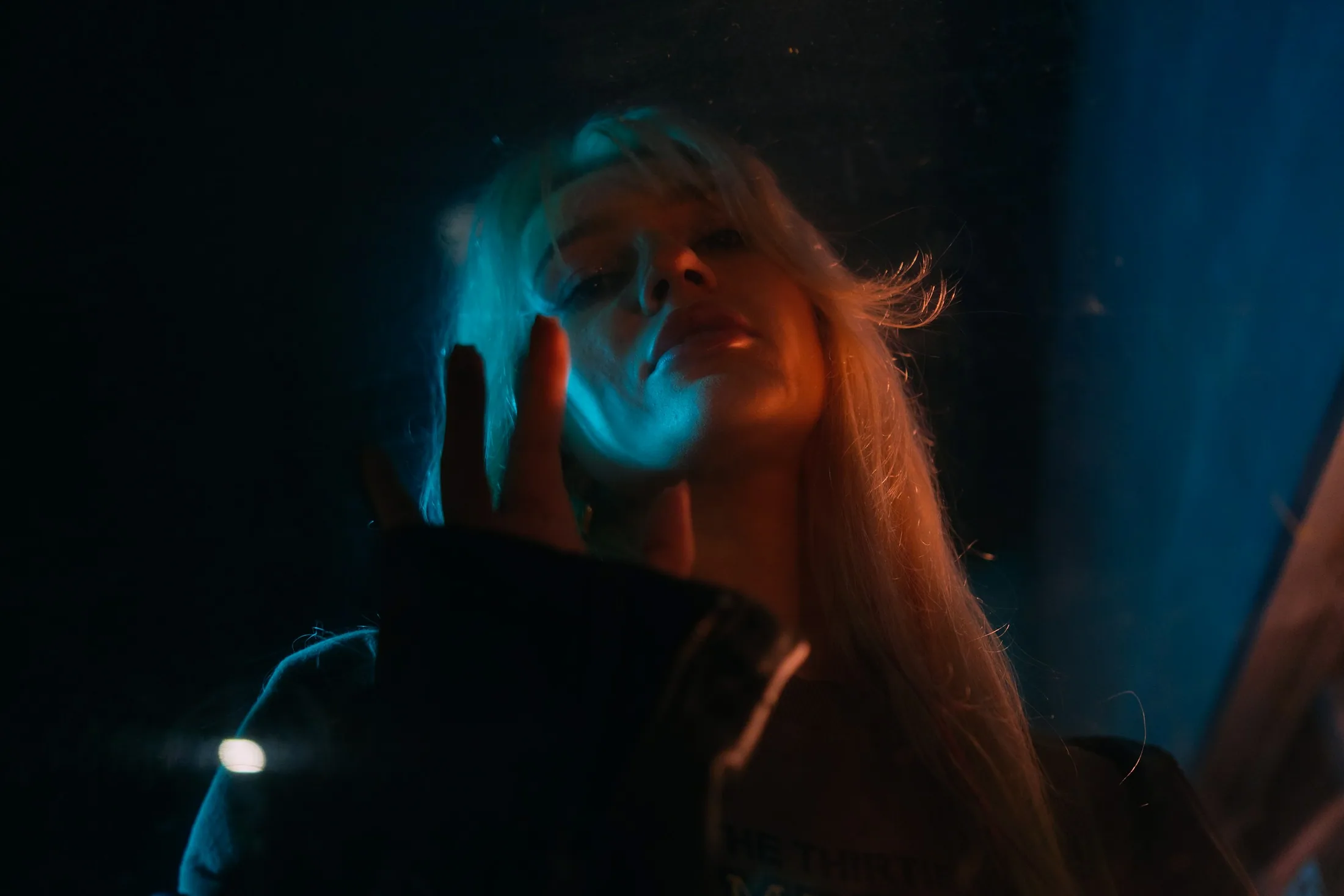 A woman lit by blue light in the dark