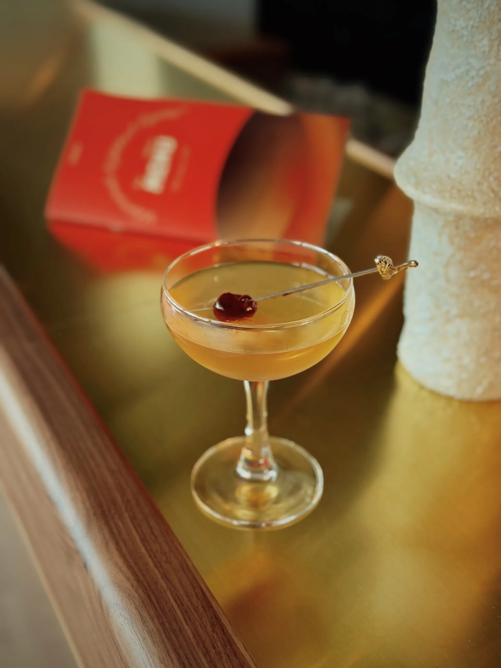 Cocktail with a cherry on a bar counter