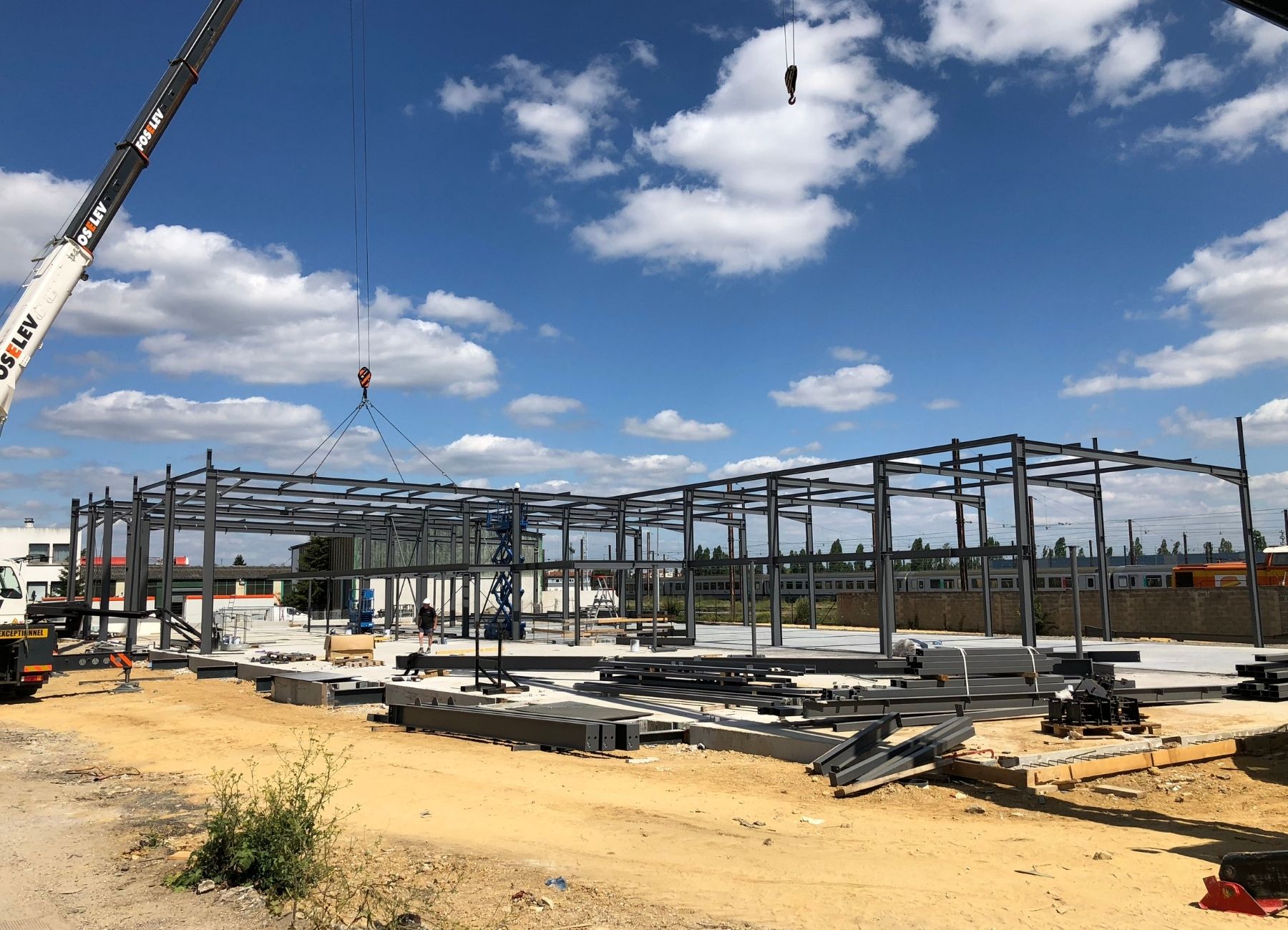 Montage d’une structure métallique sur un vaste chantier avec ossature posée.