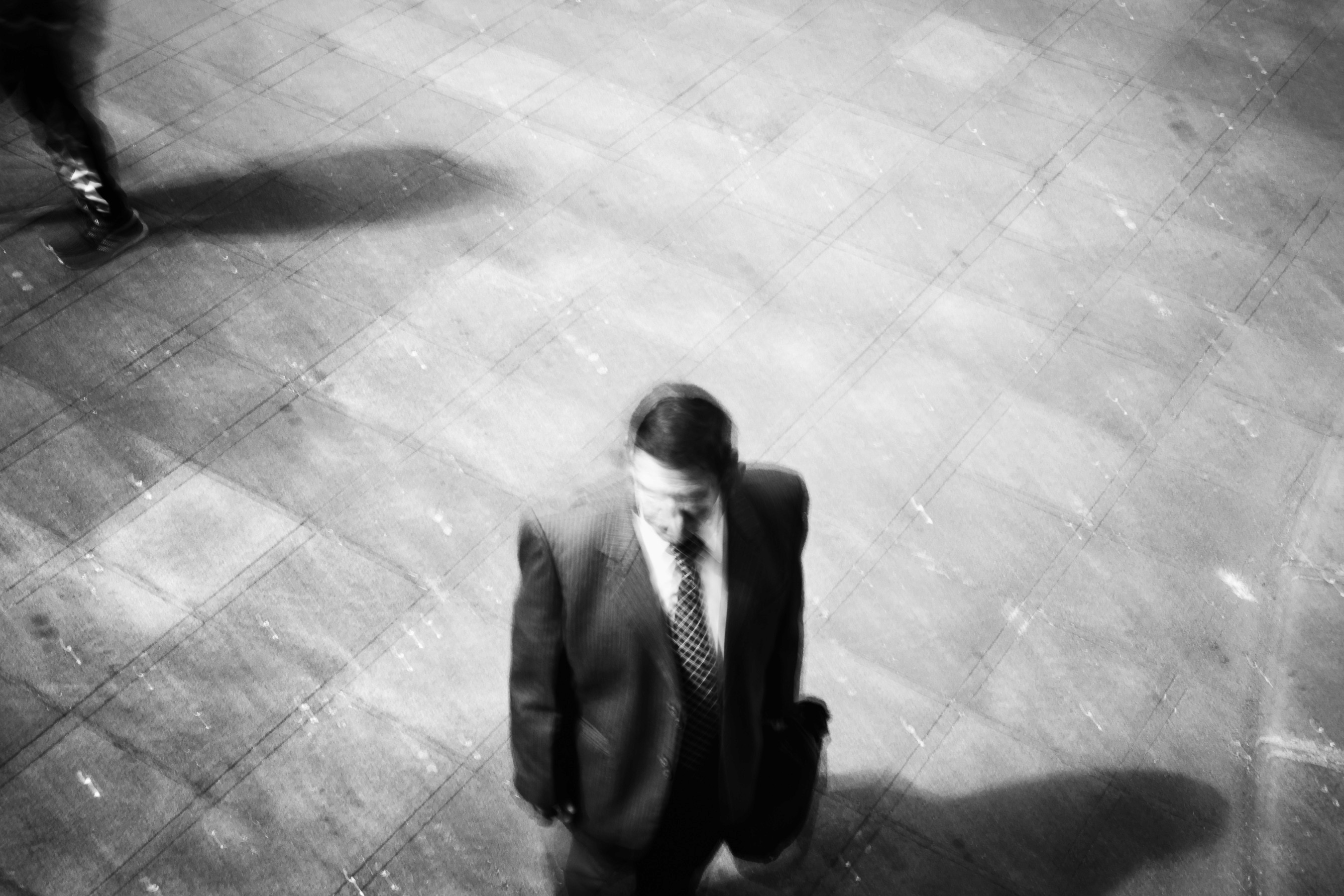A photo of man holding his suitcase, on a slow shutter, black and white