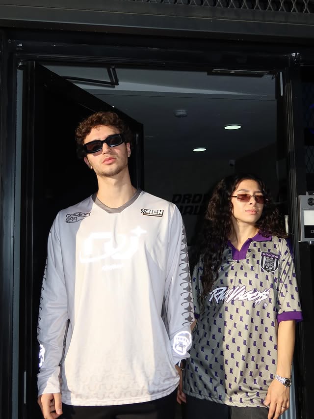 The storefront of a clothing boutique with large stone pillars and a concrete facade