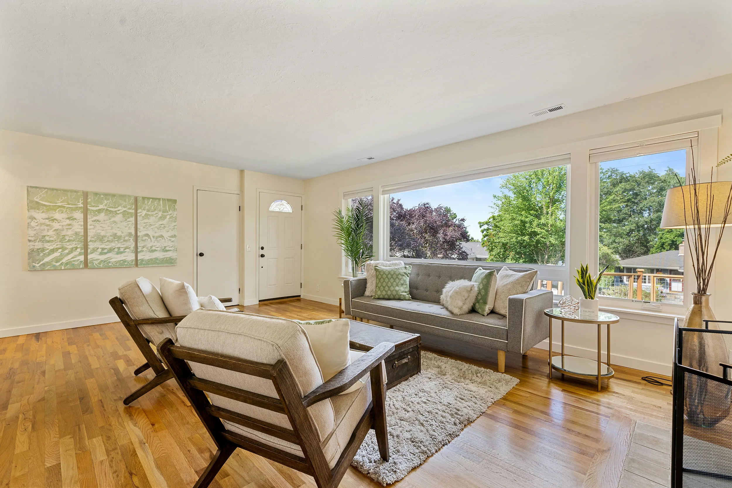 Spacious living room with large windows and hardwood floors, bright open-concept interior