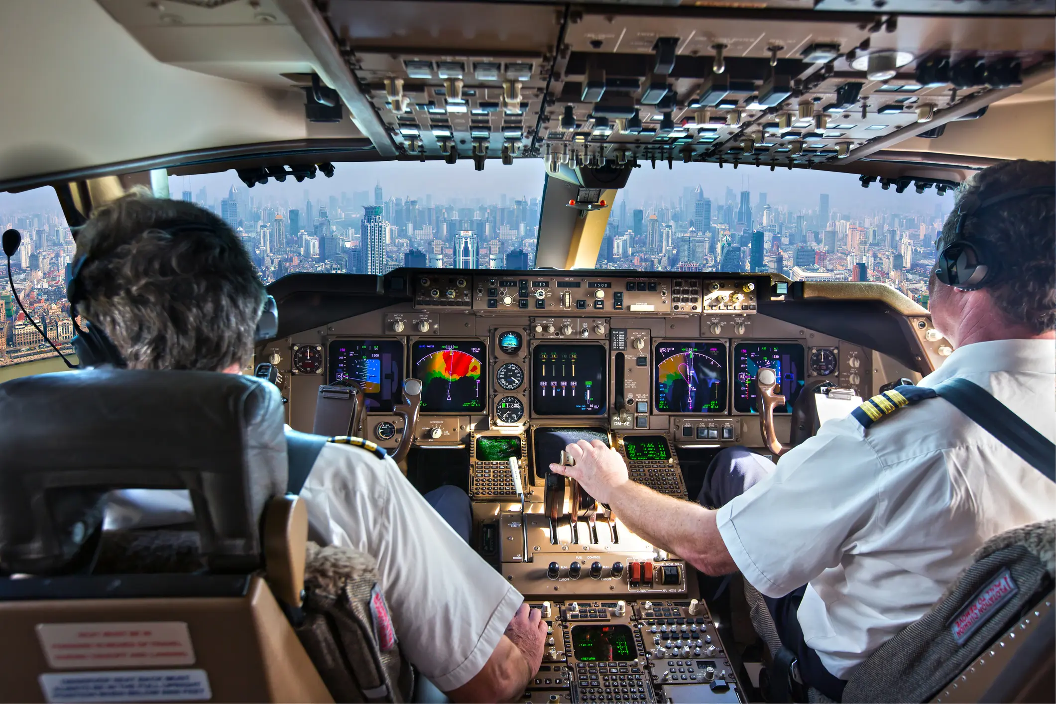 Two pilots working together in an aircraft cockpit representing high performance teaming and shared leadership