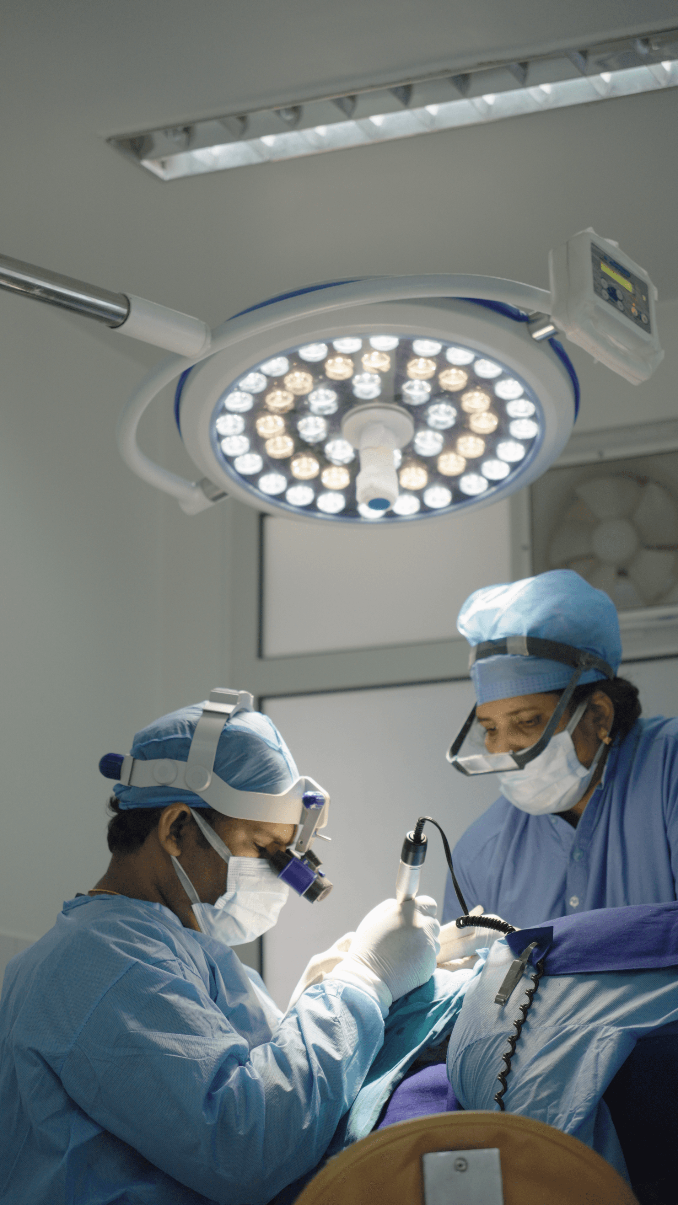 A smiling dentist in a white coat holding a clear dental aligner