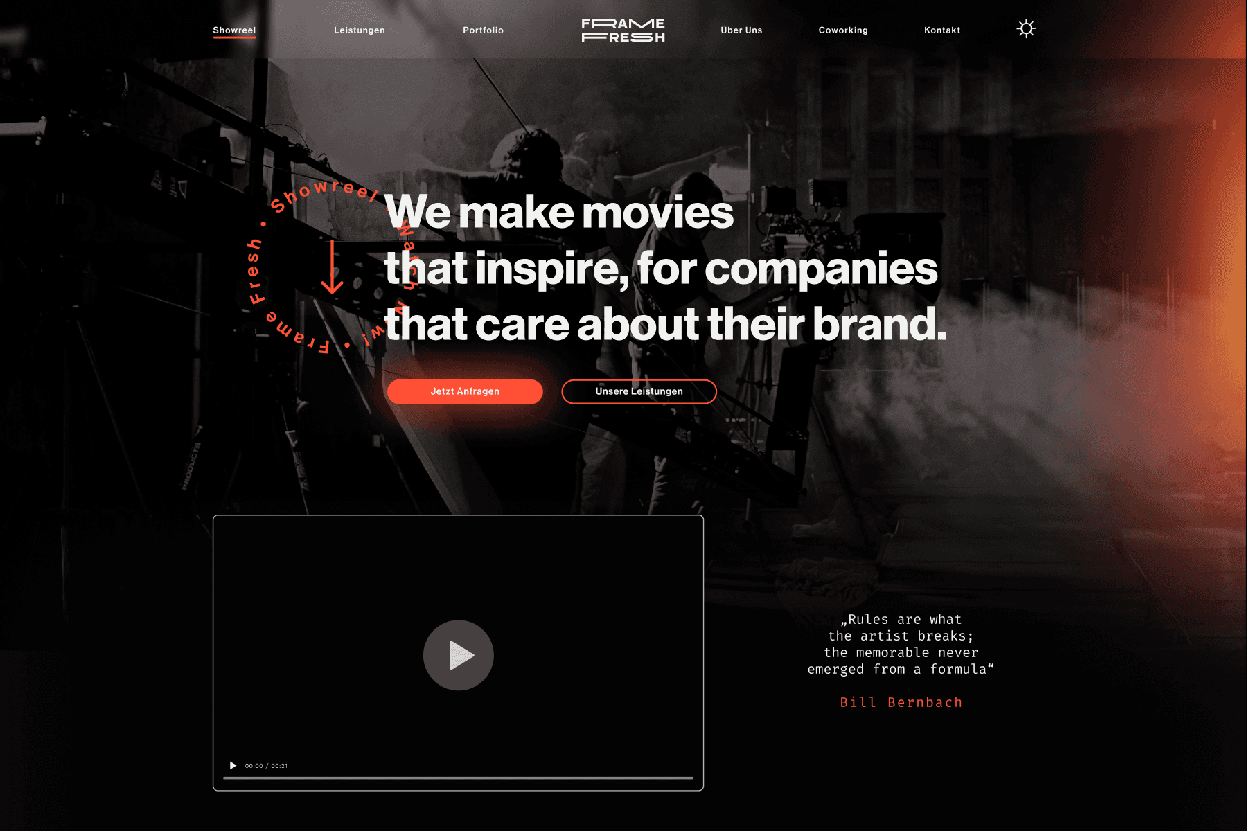 Website Hero von “Frame Fresh”, zeigt eine rot-schwarze Farbpalette mit einem Hintergrundbild von Filmproduktionsausrüstung. Überlagerter Text in Weiß sagt: “We make movies that inspire, for companies that care about their brand.” Unter dem Text ist ein Video-Player-Button und ein Zitat von Bill Bernbach: “Rules are what the artist breaks; the memorable never emerged from a formula.”