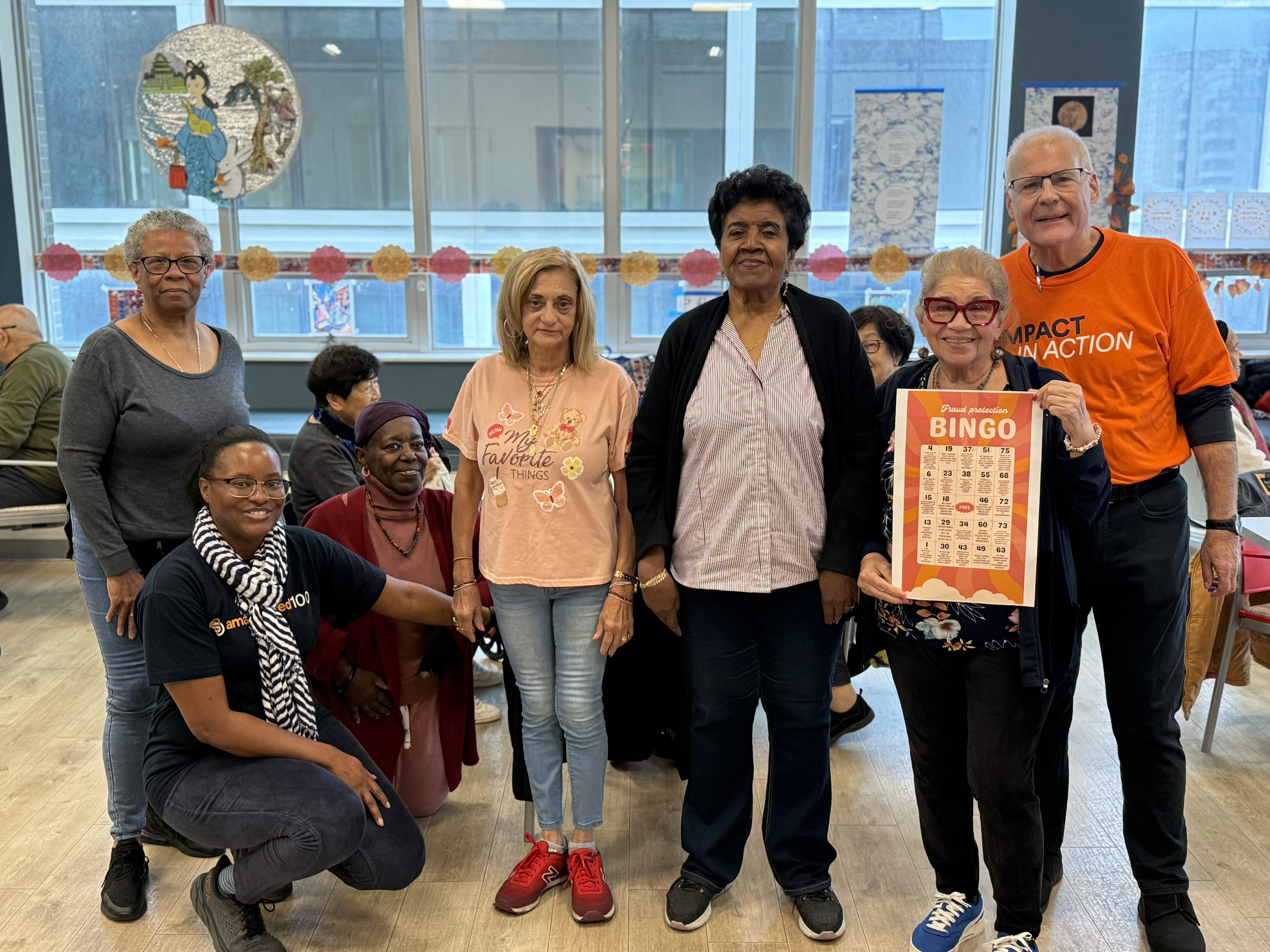  The winning participants pose with their completed bingo sheet and Amalgamated Bank volunteers.