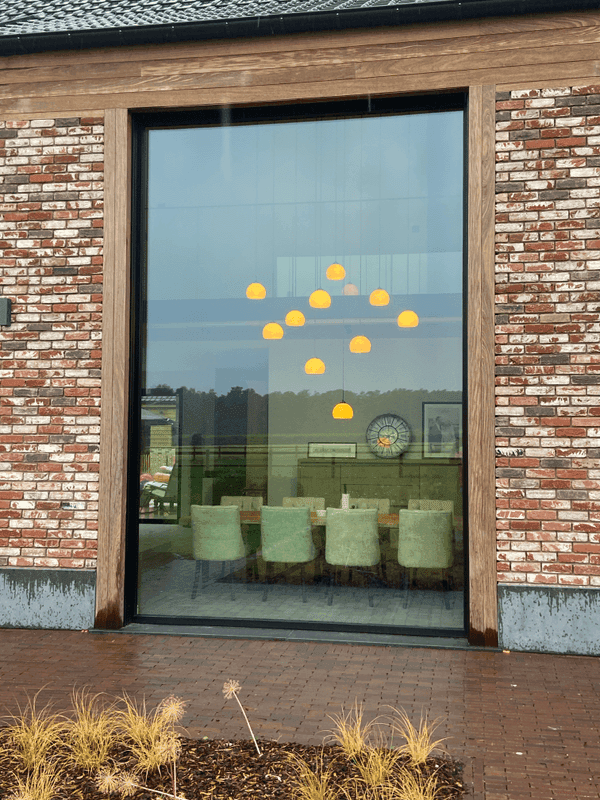 Maatwerk hanglamp van Bellini Lighting boven een tafel met warme en gerichte verlichting