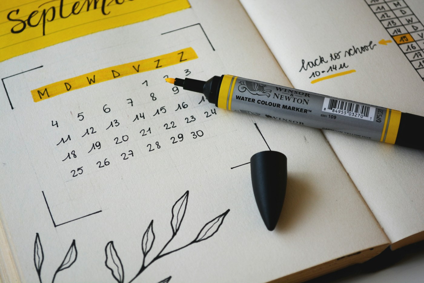 paper wall calendar with a pen resting on it