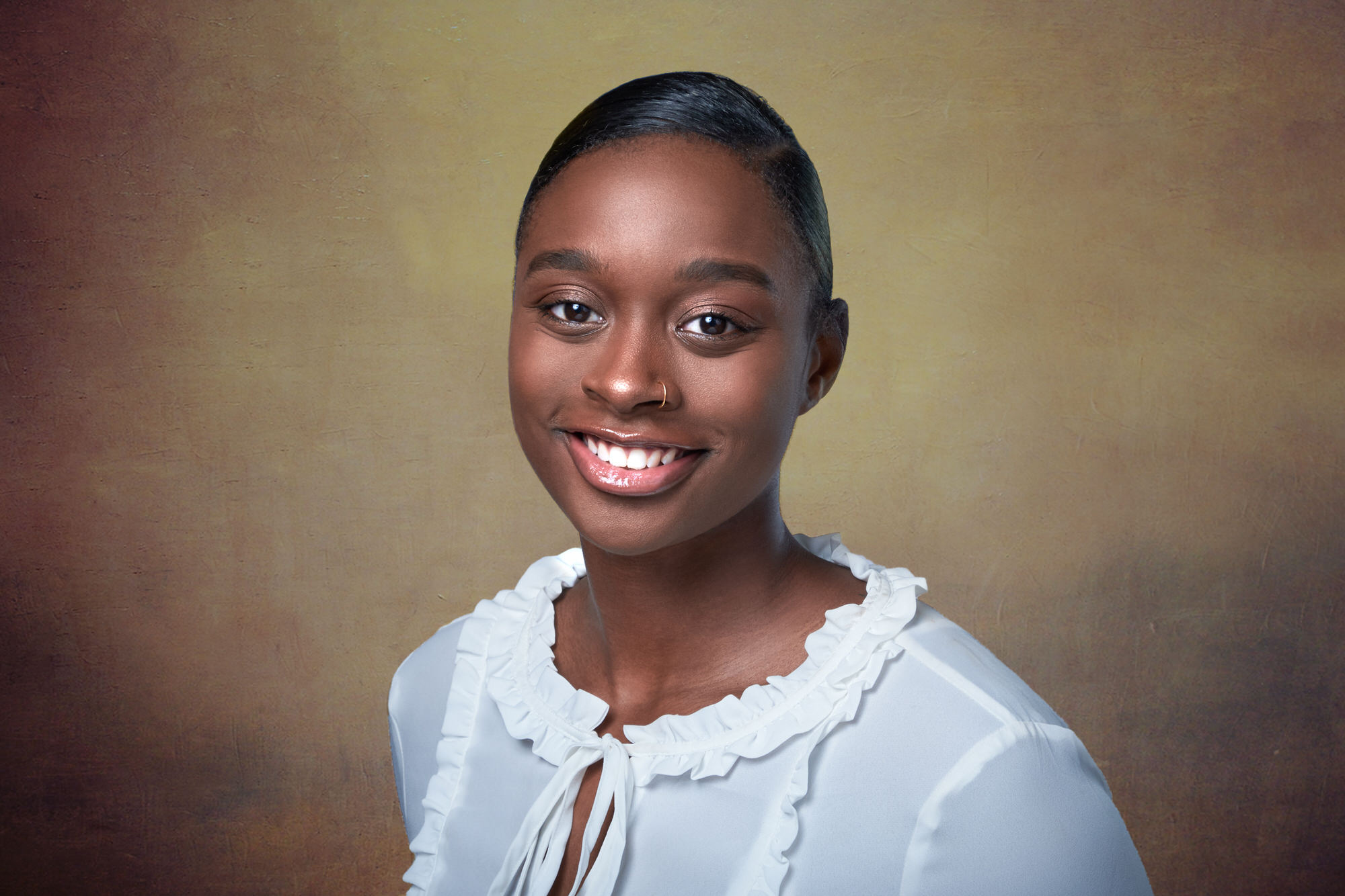 Clean studio headshot of Black woman with pulled-back hair and white ruffled blouse