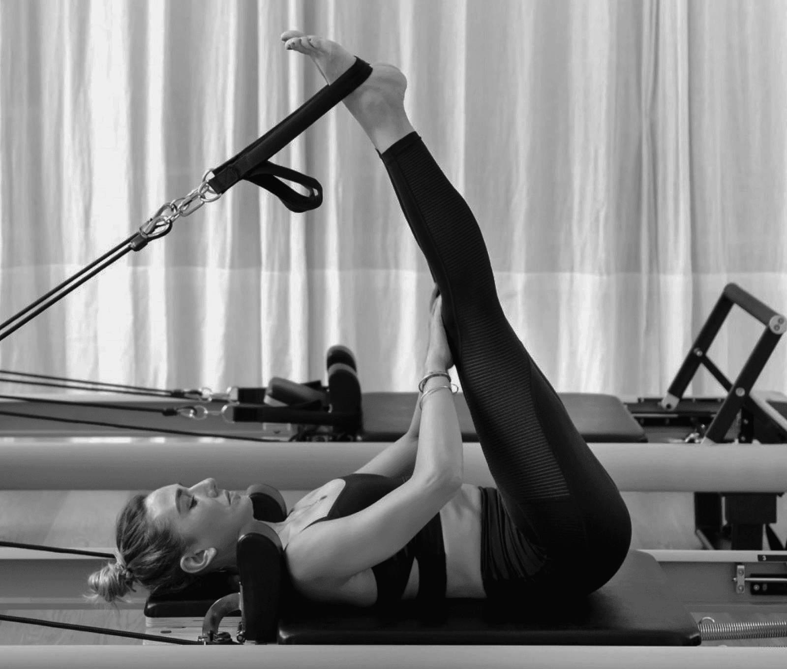 Woman practicing pilates on reformer machine