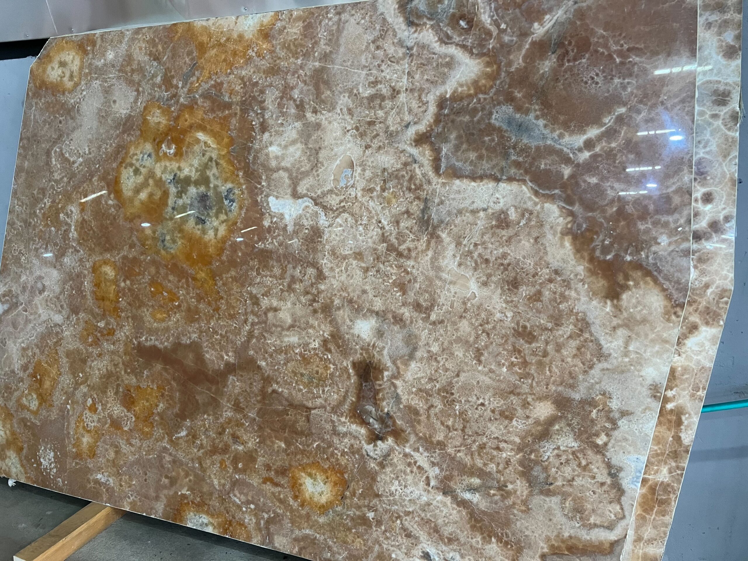 Braune Onyxplatte mit goldenen und cremefarbenen Strukturen.