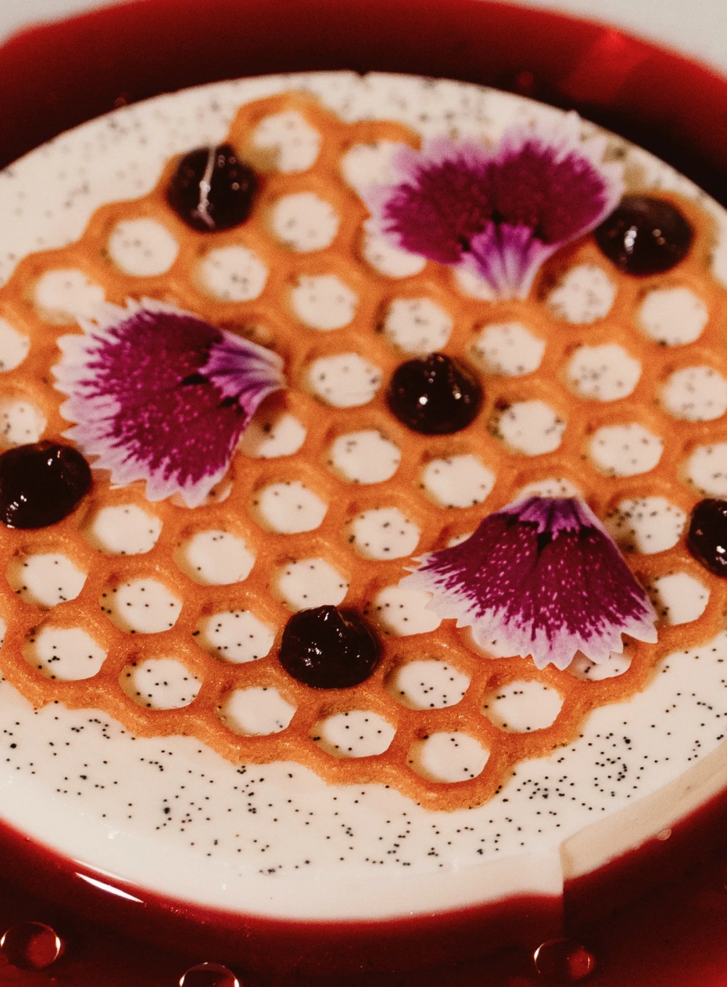 Postre de Atea en panal crujiente con flores comestibles y frutos rojos