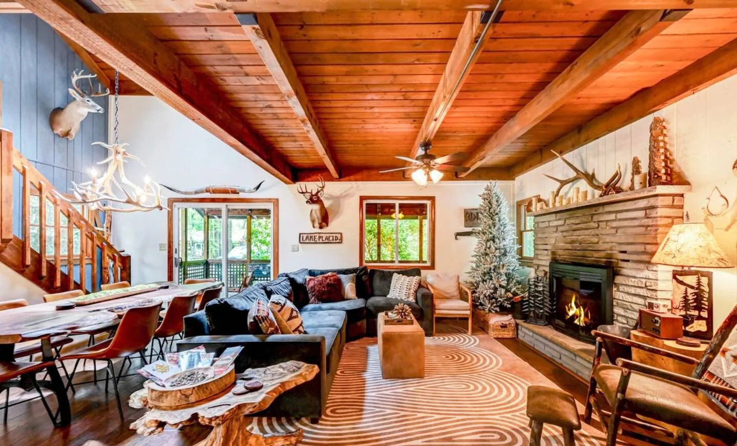 Open great room with stone fireplace, sectional and dining area at Mountain MAMA
