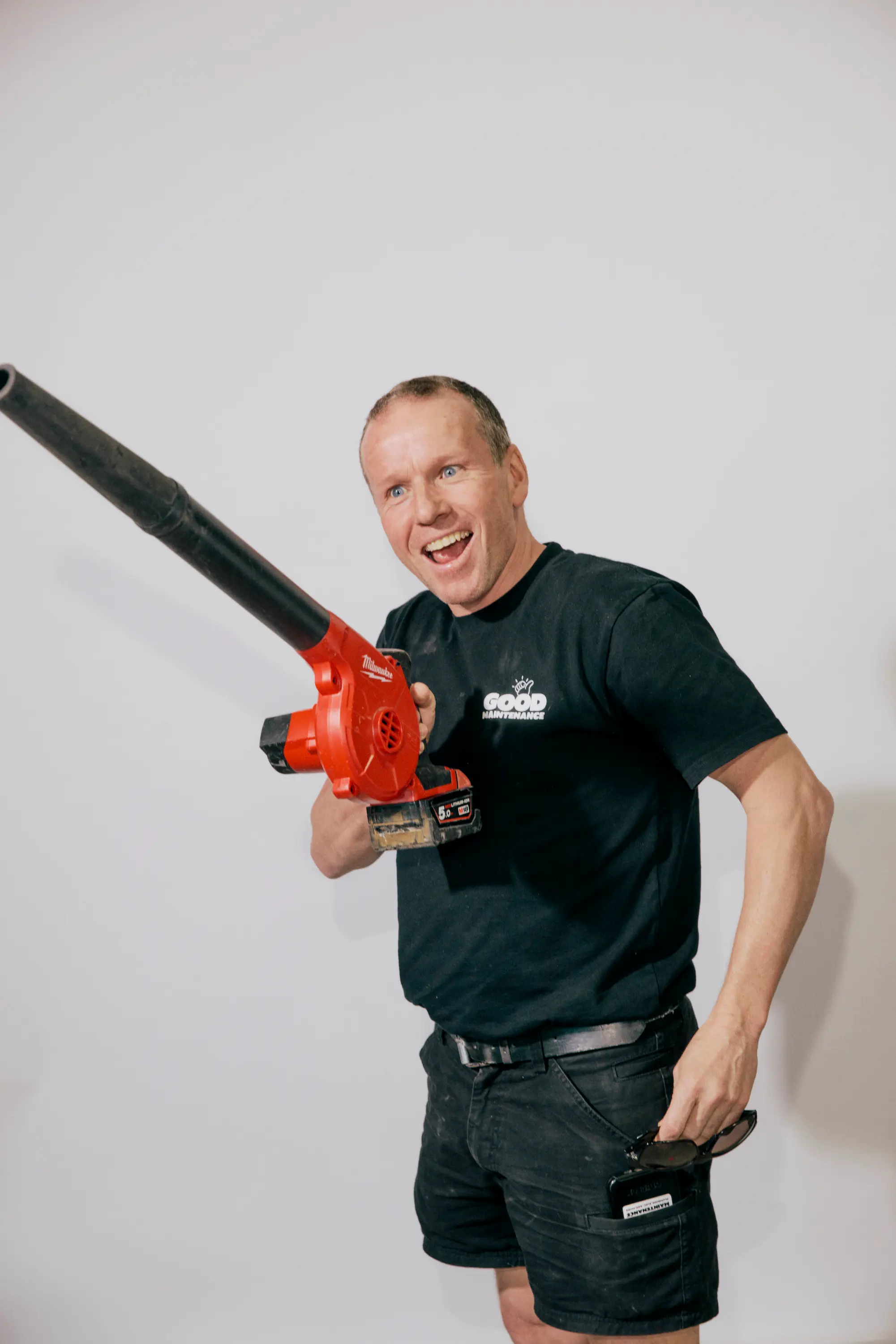 Good Maintenance Team Member playfully posing with a leaf blower