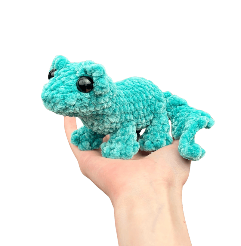 A cute, handcrafted plush acorn toy with brown yarn spikes and large, friendly eyes sits facing forward on a white background.