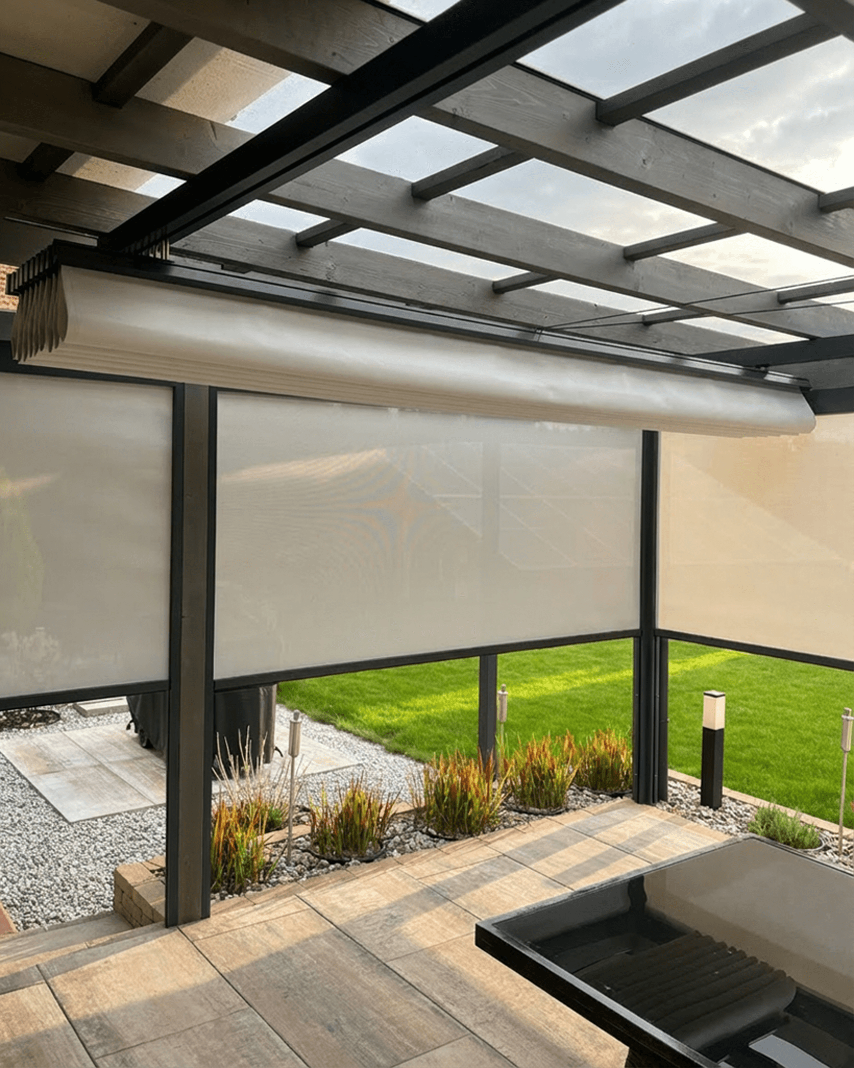 Nowoczesne rolety zewnętrzne typu Screen zamontowane na szklanej pergoli tarasowej. HeyShade Pruszków – skuteczna ochrona przed słońcem i wiatrem na tarasie.