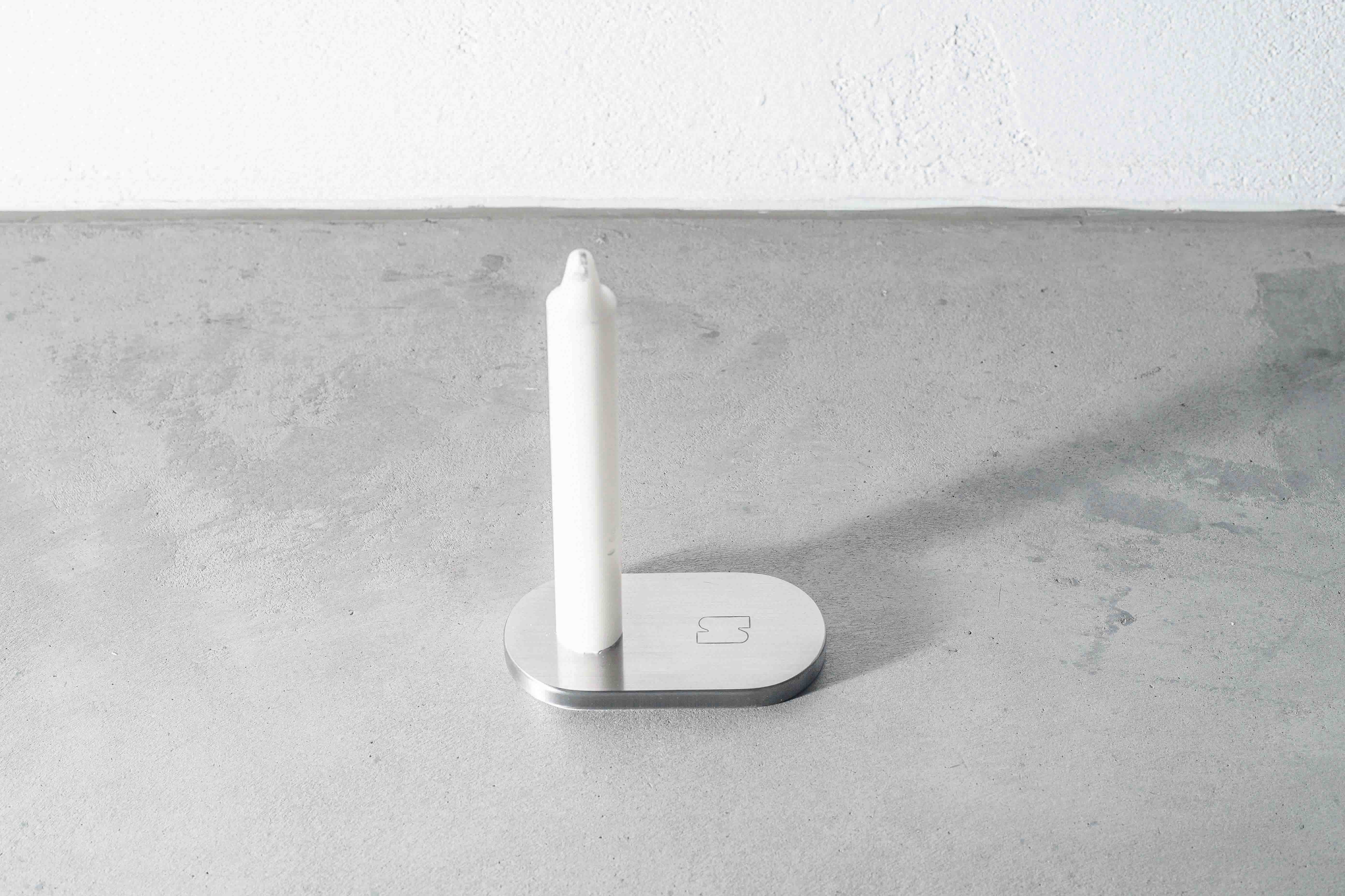 a metal candle holder on a concrete floor