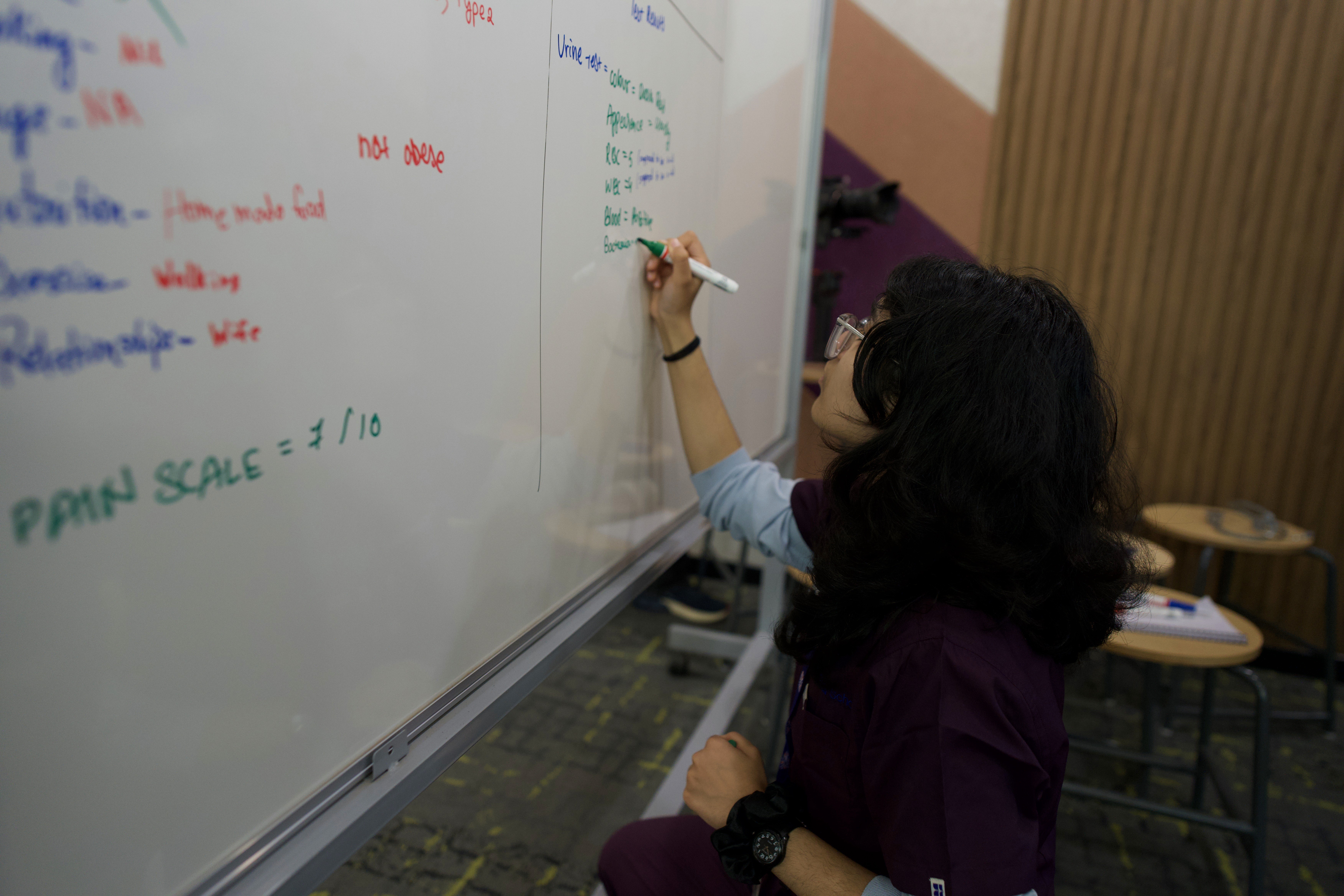 Ideation by a student on a whiteboard, fostering critical thinking