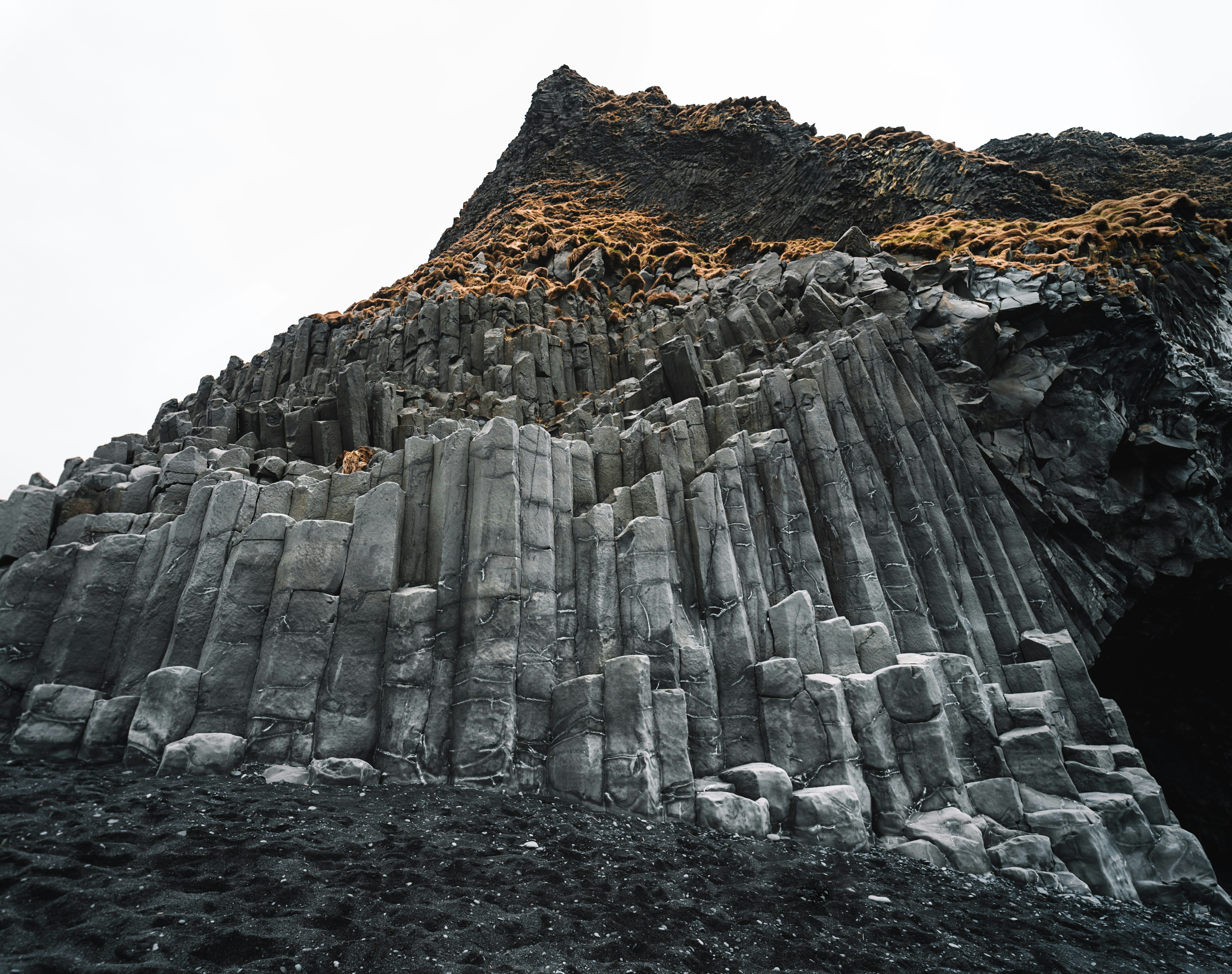 Towering basalt columns along the shore of Reynisfjara Black Sand Beach in Iceland.