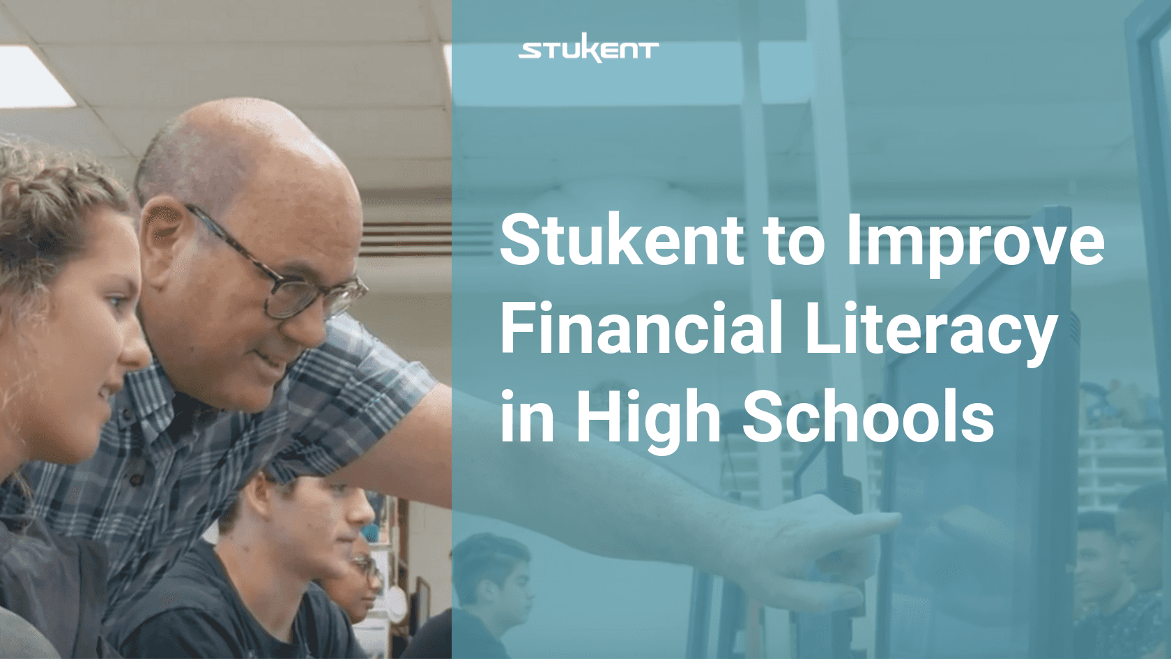Instructor pointing at a computer screen to a student. Text to the rights says "Stukent to Improve Financial Literacy in High Schools"