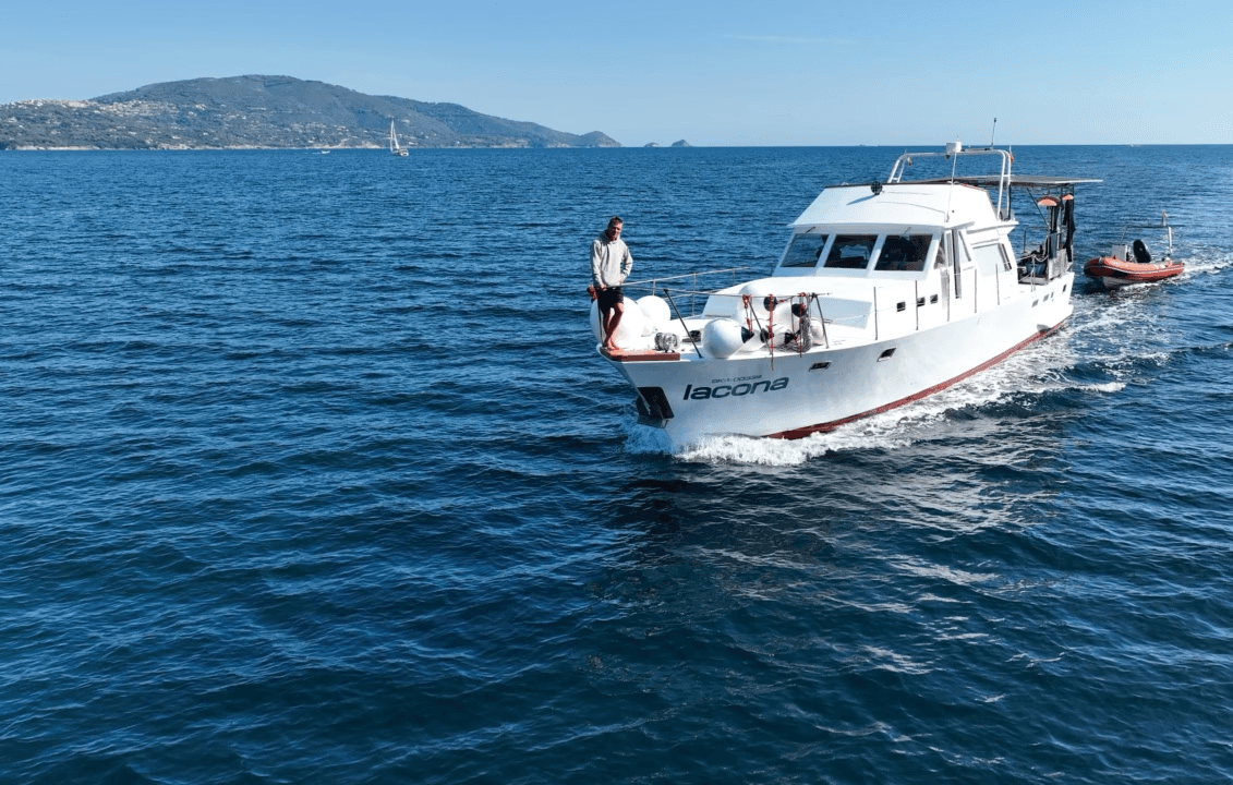 a woman scubas over a colorful coral reef