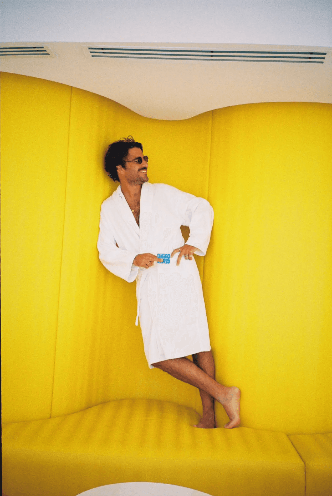 Antonio Bellido posando en batín sobre fondo amarillo