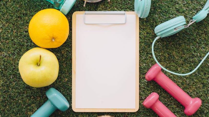A man and a woman playing Jenga, carefully pulling out a block from a tall stack.