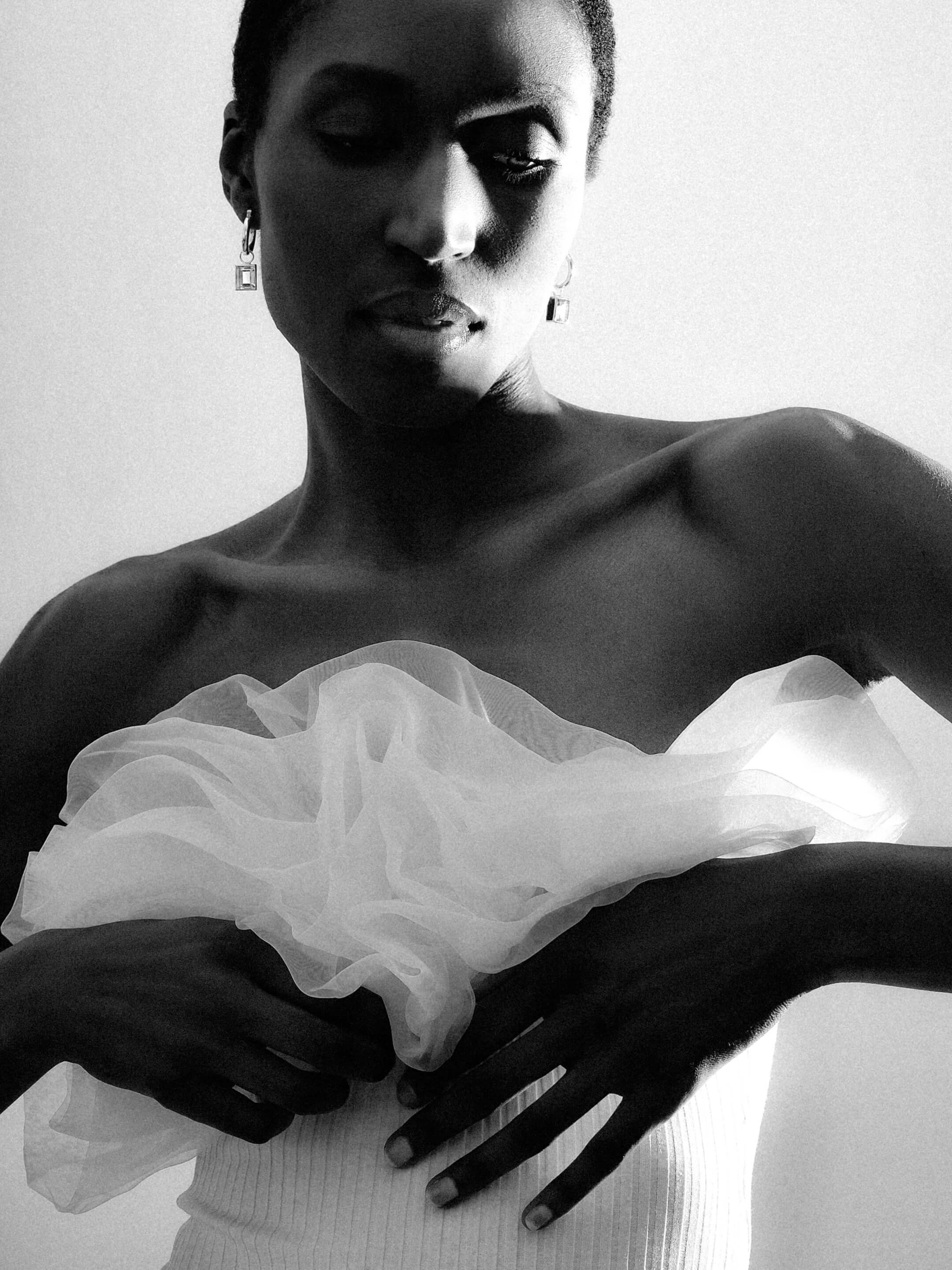 High-contrast black-and-white fashion portrait featuring Pearloir geometric drop earrings and sculptural styling