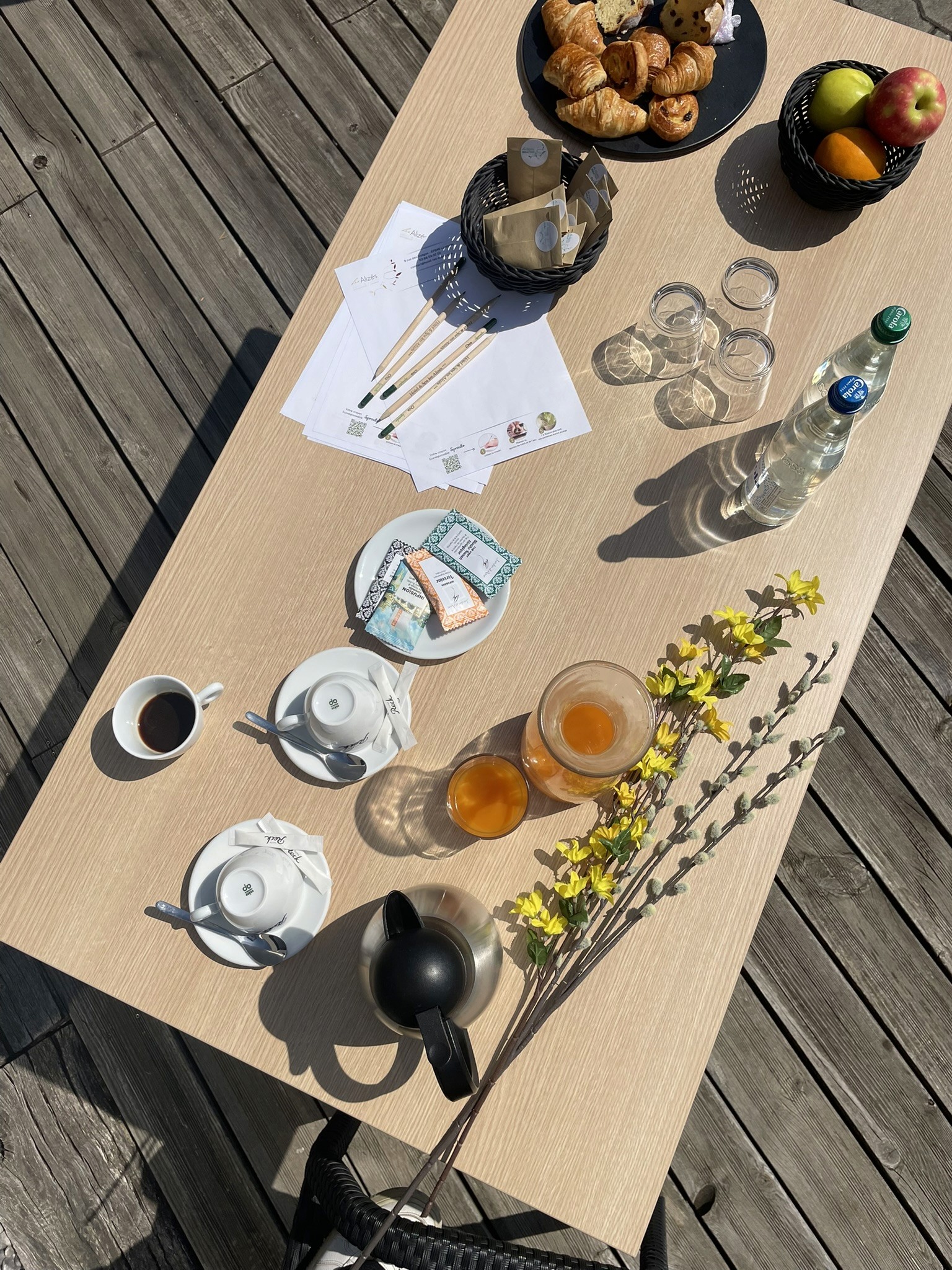 Moment de détente en terrasse avec boissons et documents de travail – cadre idéal pour un séminaire en Alsace.