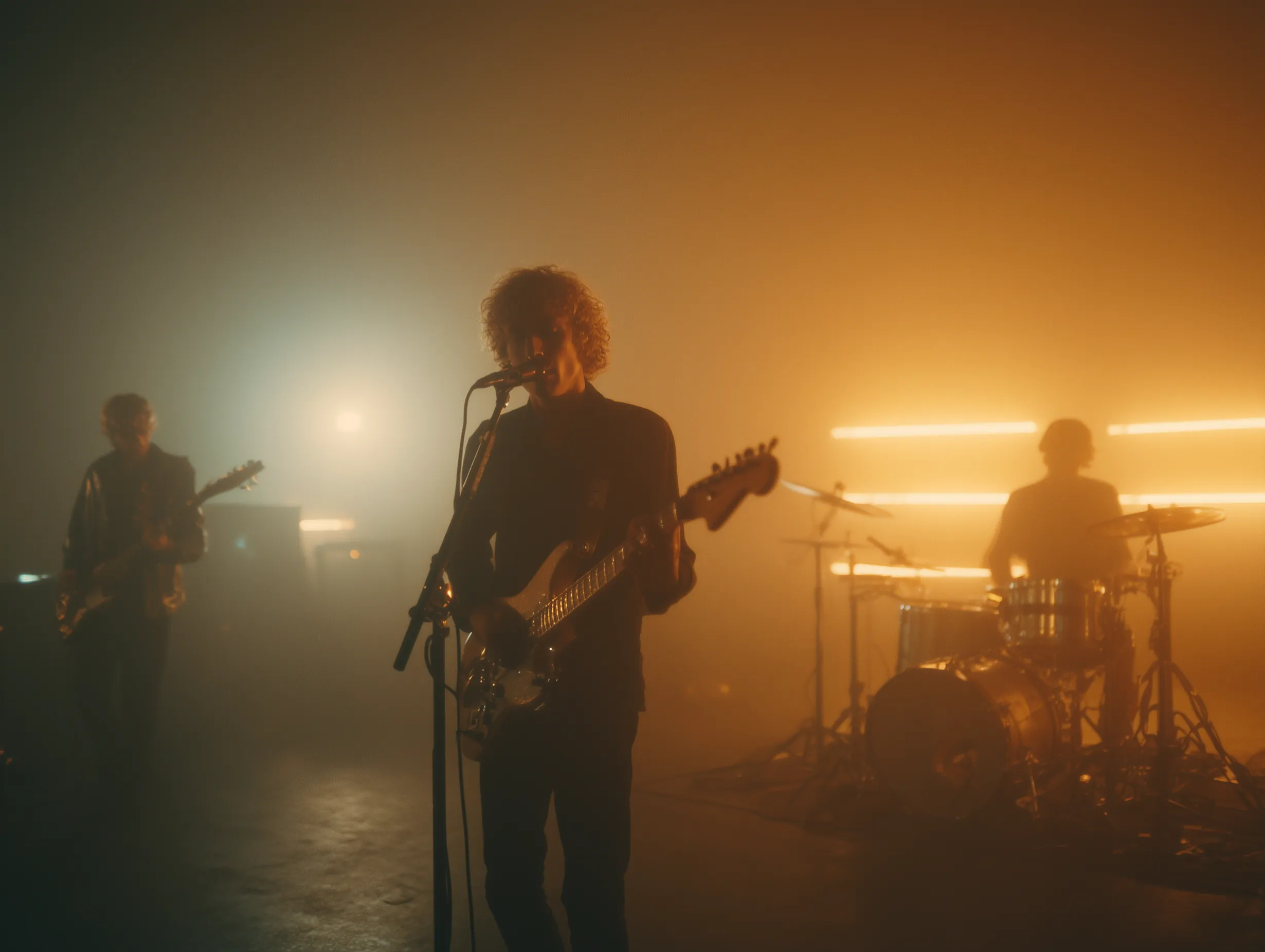 Band performing on foggy stage with warm lights