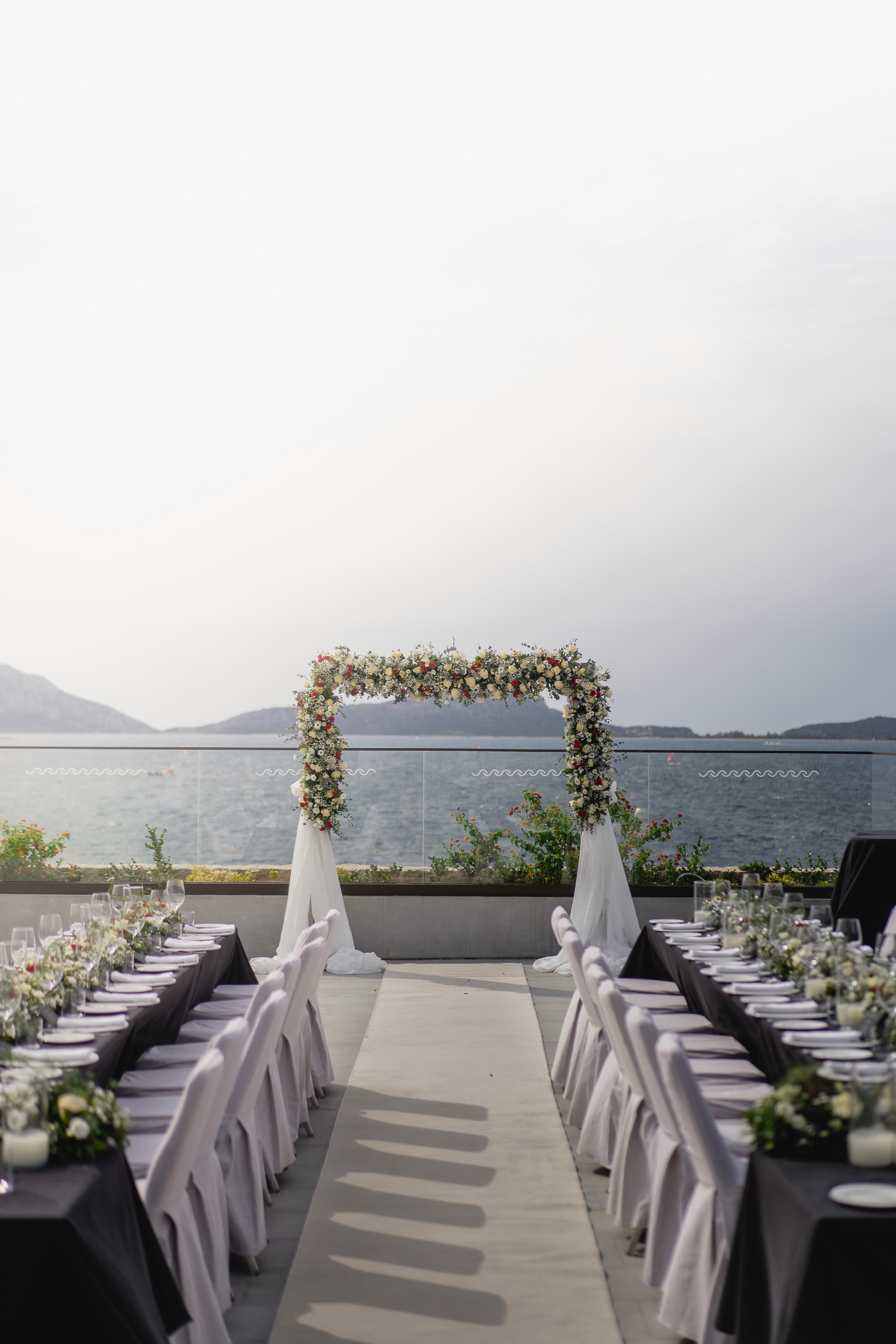 Elegant floral arch with white drapes for a coastal civil wedding ceremony in Costa Navarino Greece