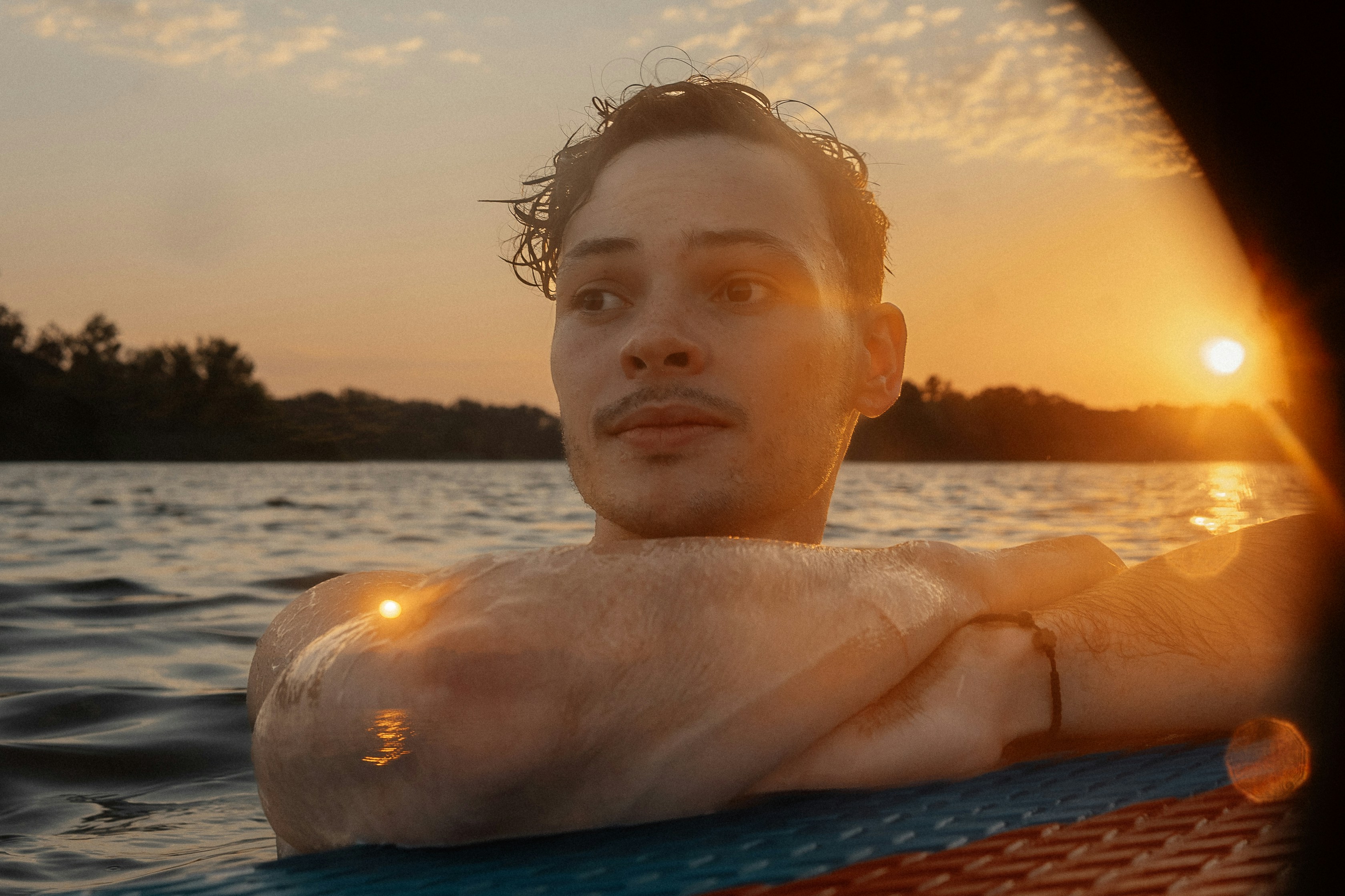 a man sitting on top of a surfboard in the water