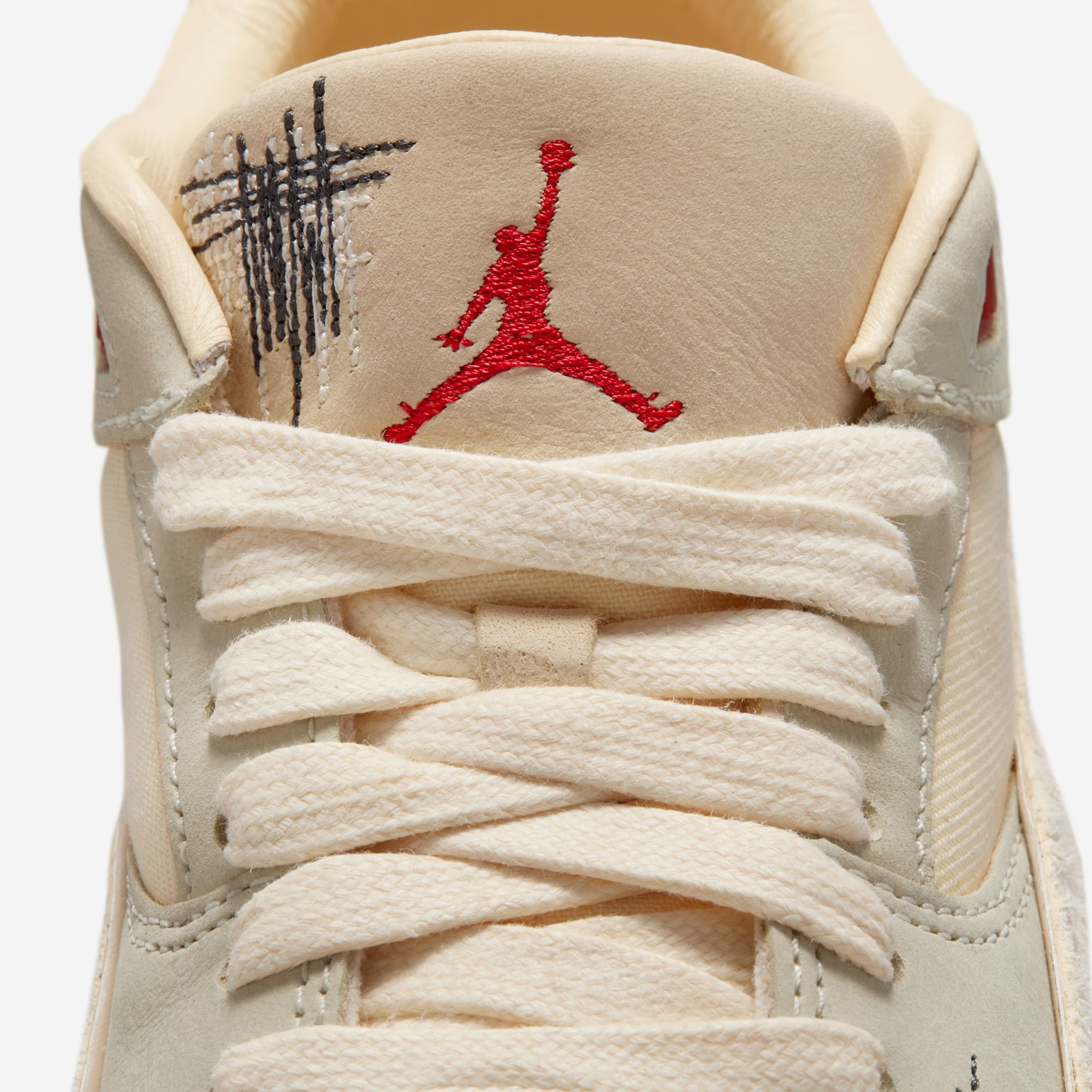 Close-up of the Téla D’Amore x Jordan Flight Court "Coconut Milk" sneaker, highlighting its mixed textures of smooth leather, hairy suede, and denim.