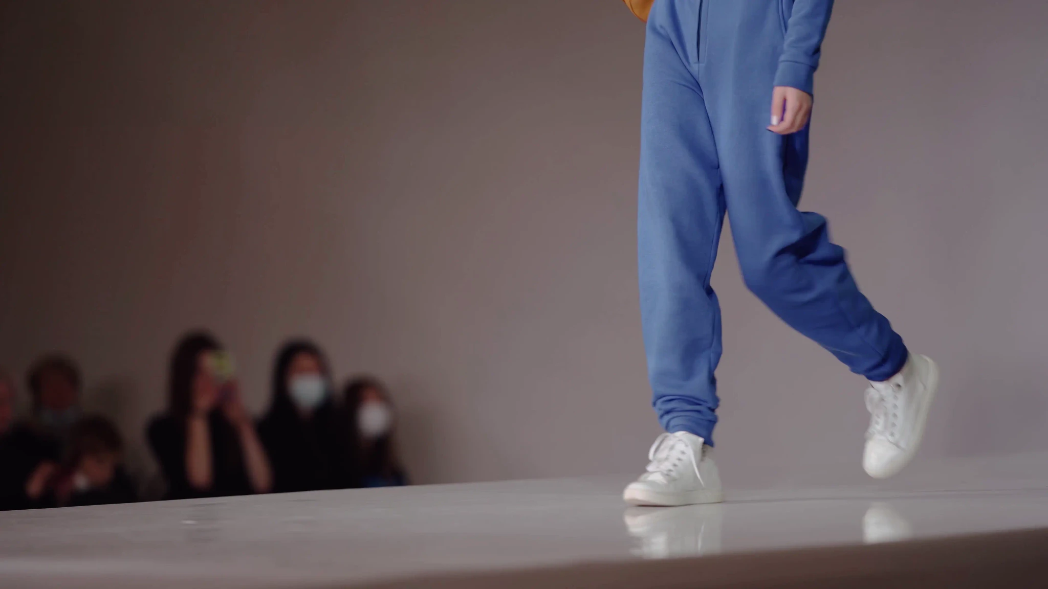 The legs of a girl in blue pants on the podium