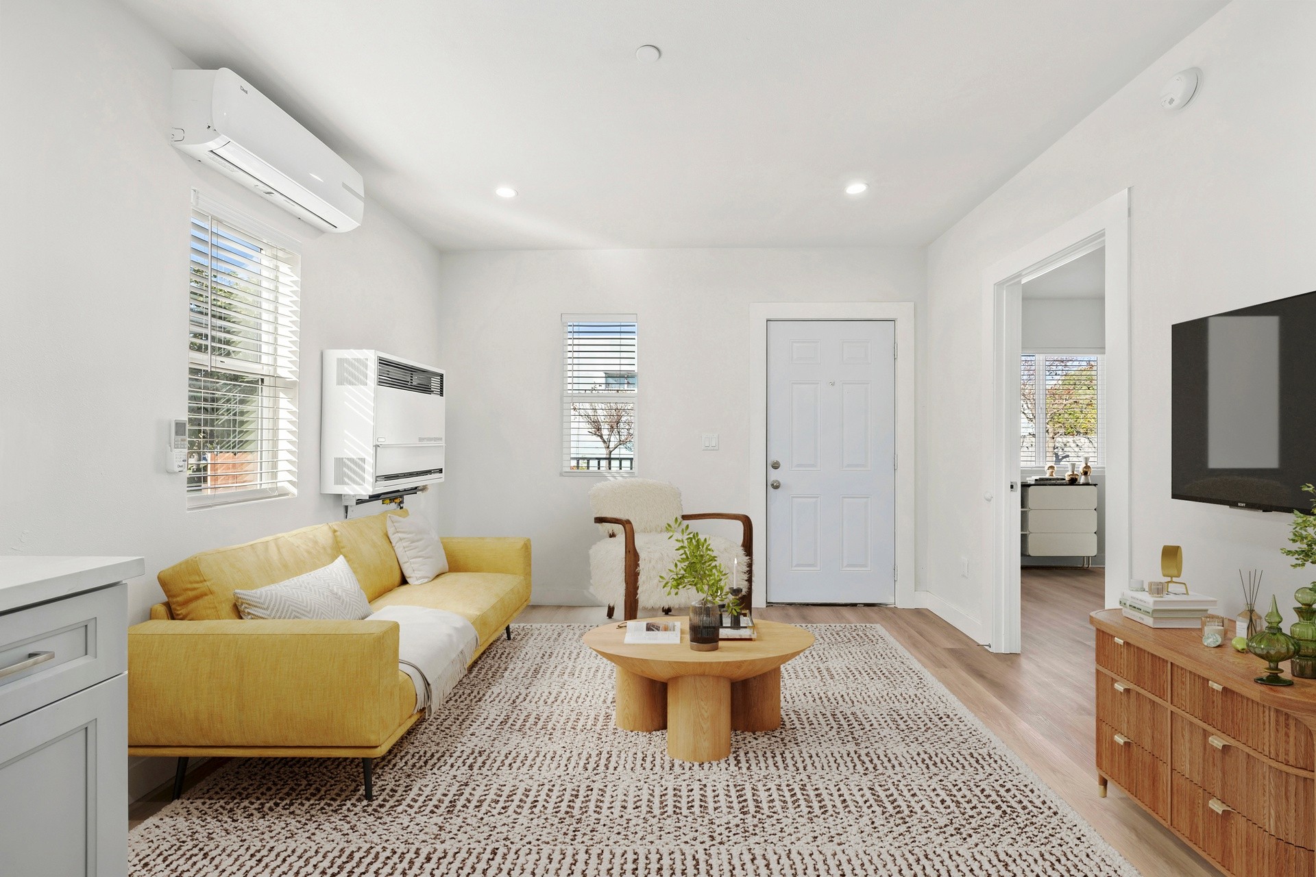Sunlit living room with split system AC, modern finishes, and clean contemporary layout at 1038 E 53rd