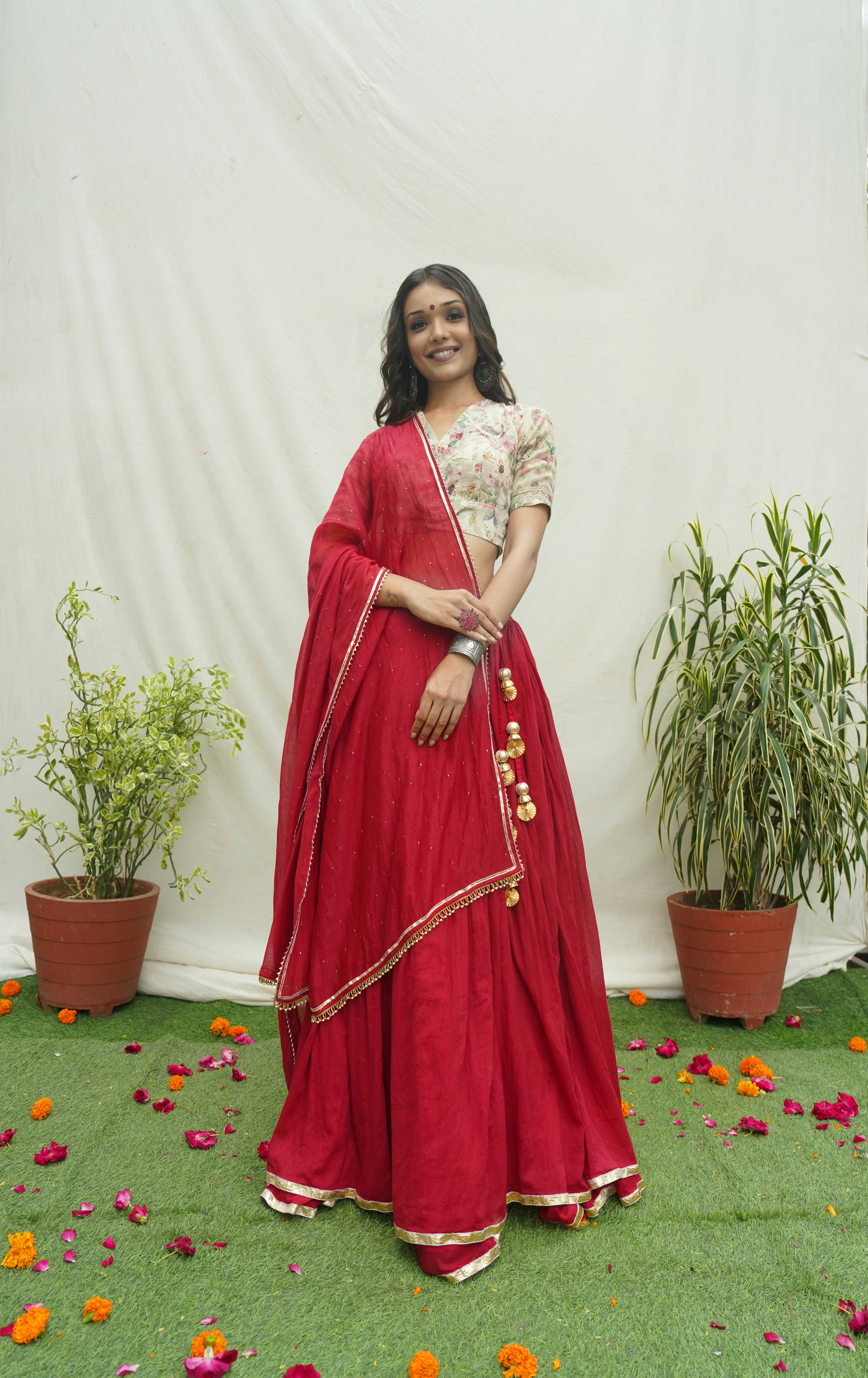 A woman in a red lehenga with a white top.