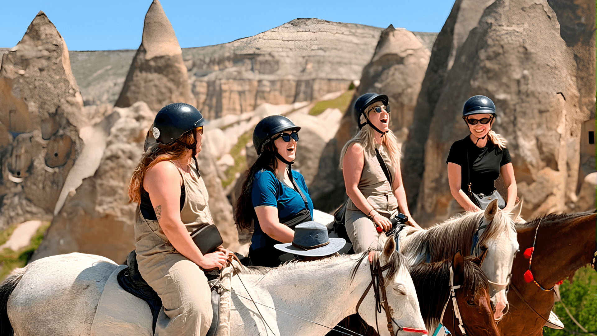 Small group travelers exploring Cappadocia, Türkiye on horseback among the region’s iconic rock formations and valleys.