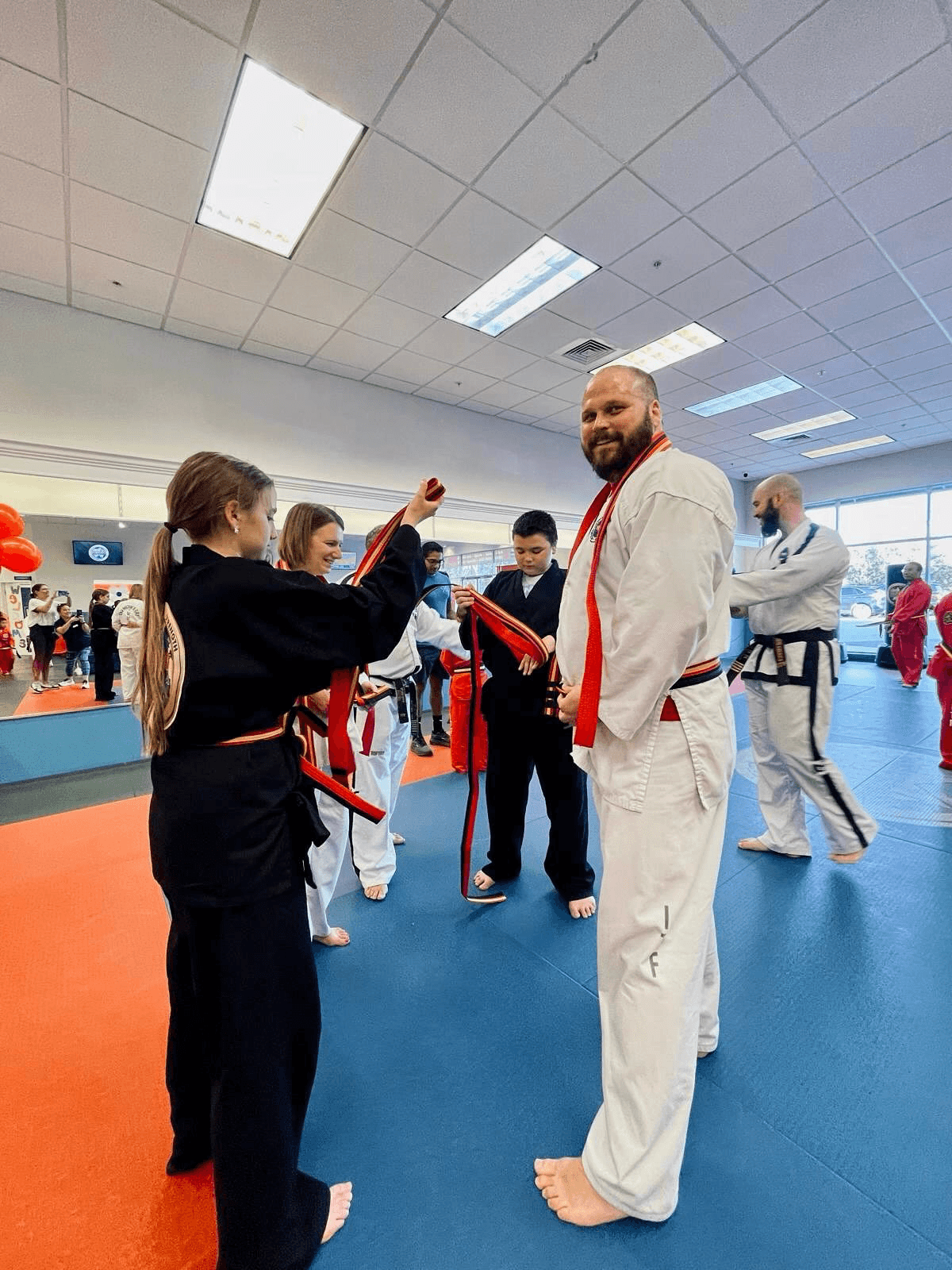Family celebrating after receiving new belt in a graduation.