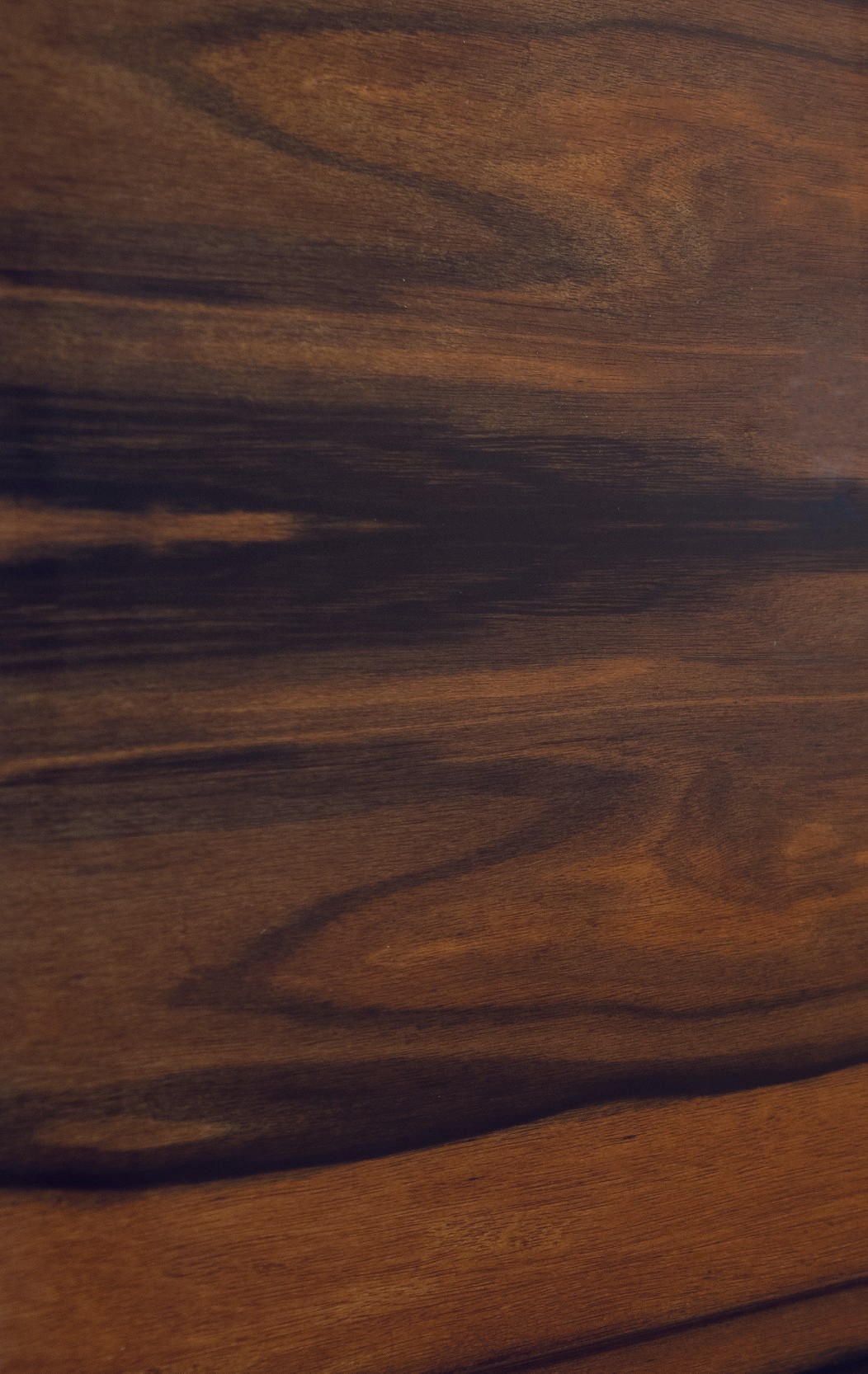 A close-up of the piano's side and lid, highlighting the striking Macassar wood grain and high-gloss finish.