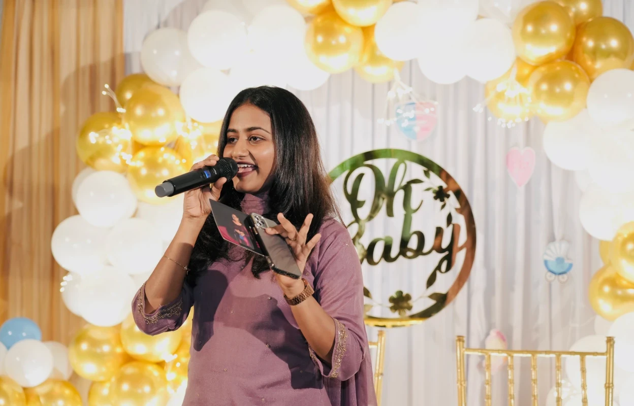 Female emcee speaking into a microphone at a birthday celebration