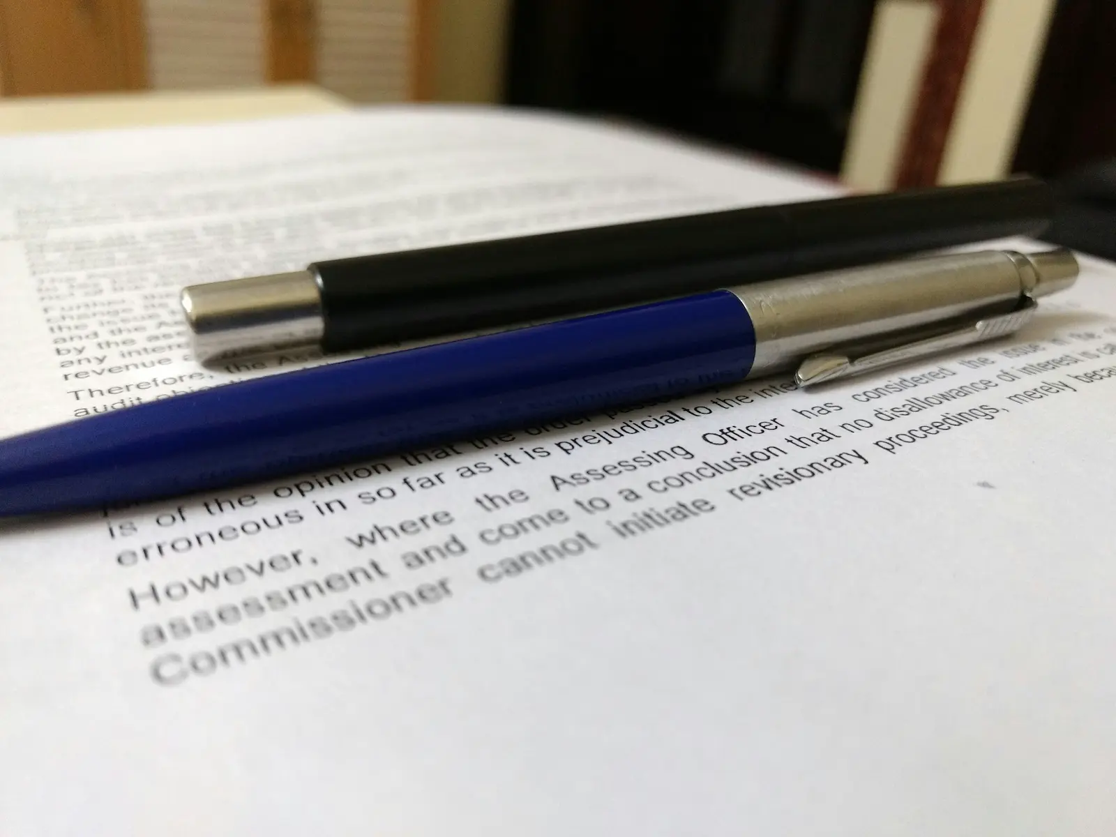 Close-up of pens resting on a printed legal document, symbolizing getting started with drafting a demand letter.