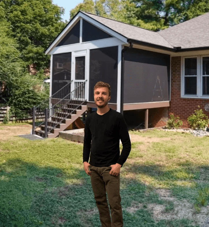 Modern living room with abstract art, beige sectional sofa, indoor plants, and large windows.