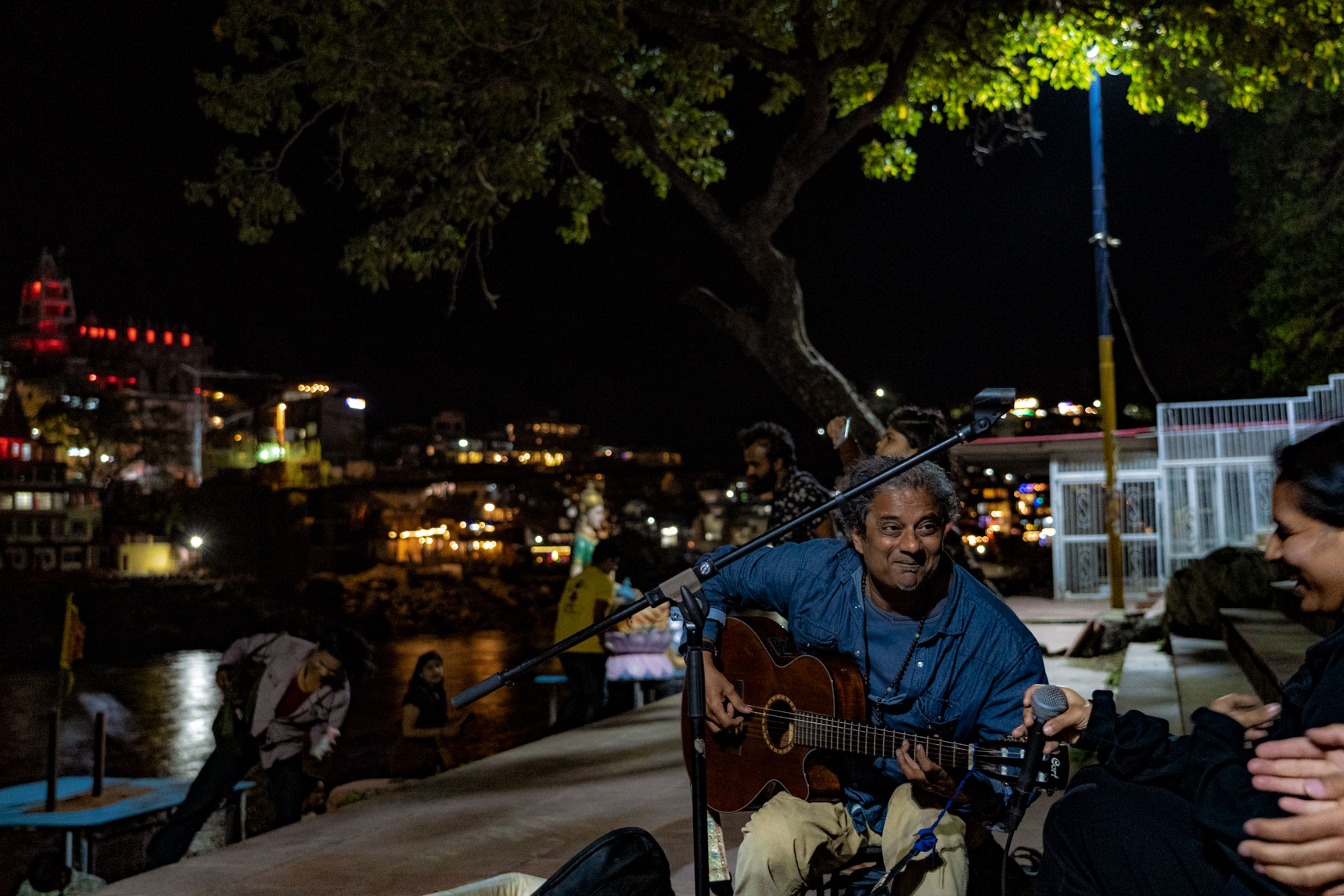 A street performer at the Sai Ghat danvati to the Ganga River playing a guitar in Rishikesh, India