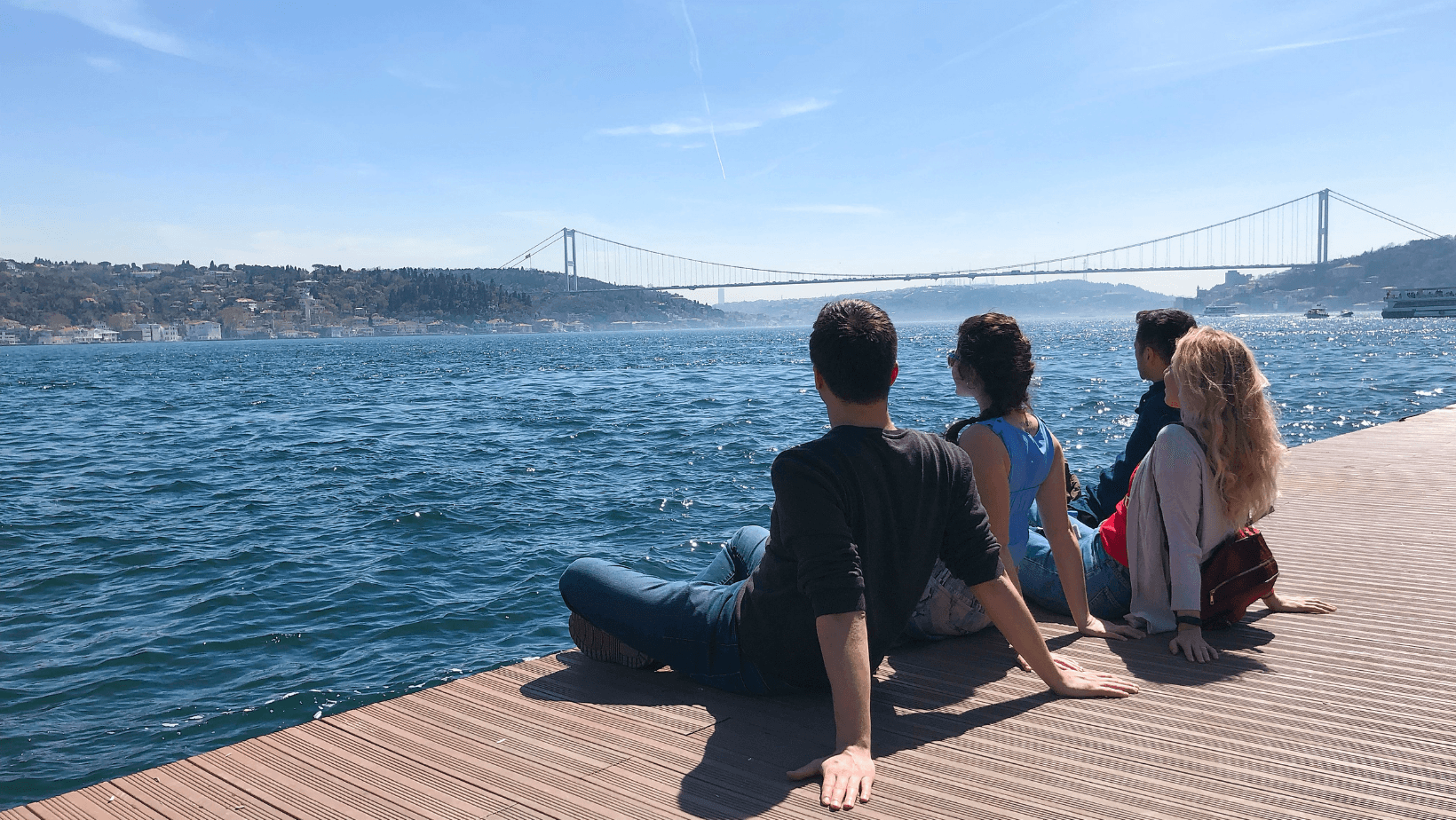 Travelers enjoying the Bosphorus view in Istanbul, Türkiye on a sunny day