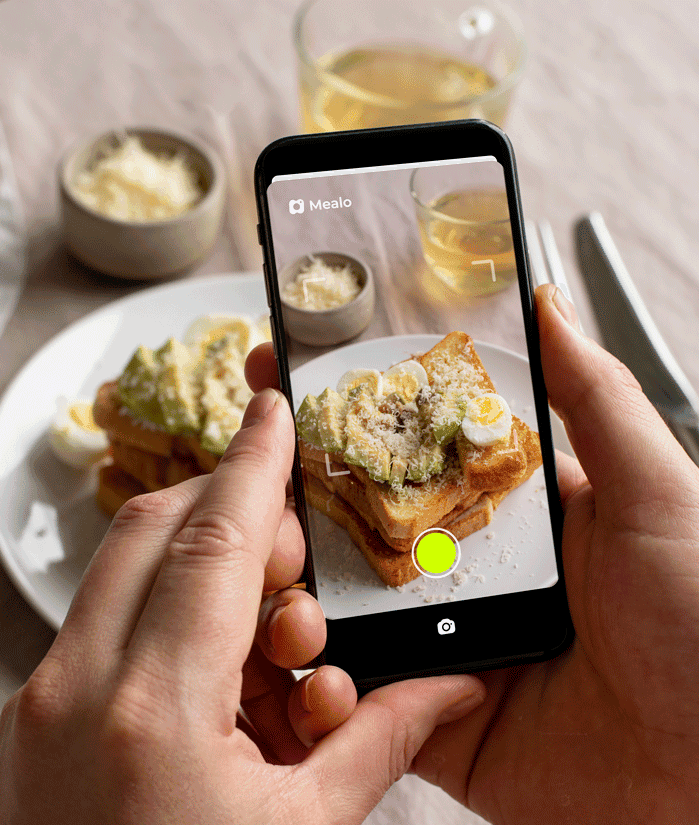 User taking a photo of a meal with Mealo app for automated calorie tracking