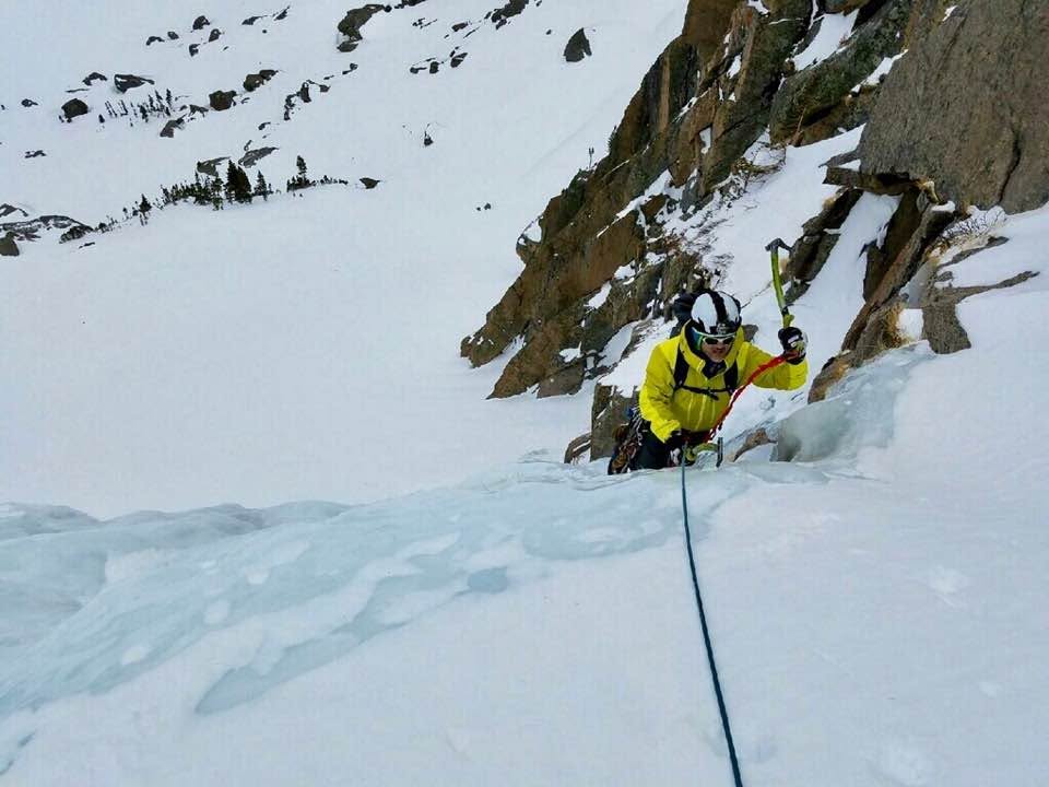 Climber swings into the ice on a pitch of West Gully above Black lake in Rocky mountain national park