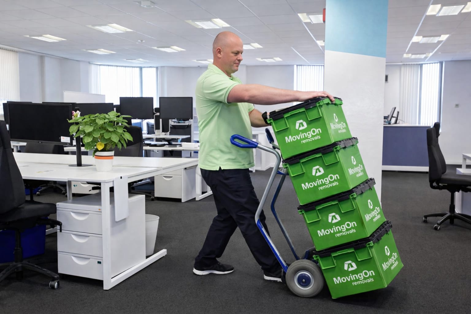 Professional commercial mover transporting secure green IT crates on a trolley through a modern office, highlighting our strategic office relocation services.